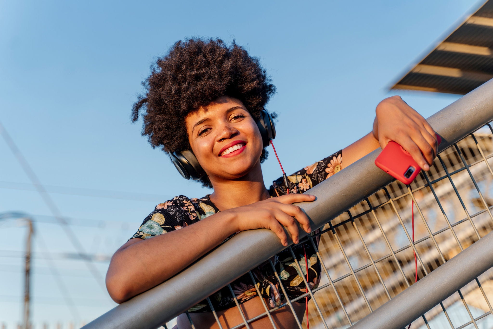 Woman with red smartphone and headphones