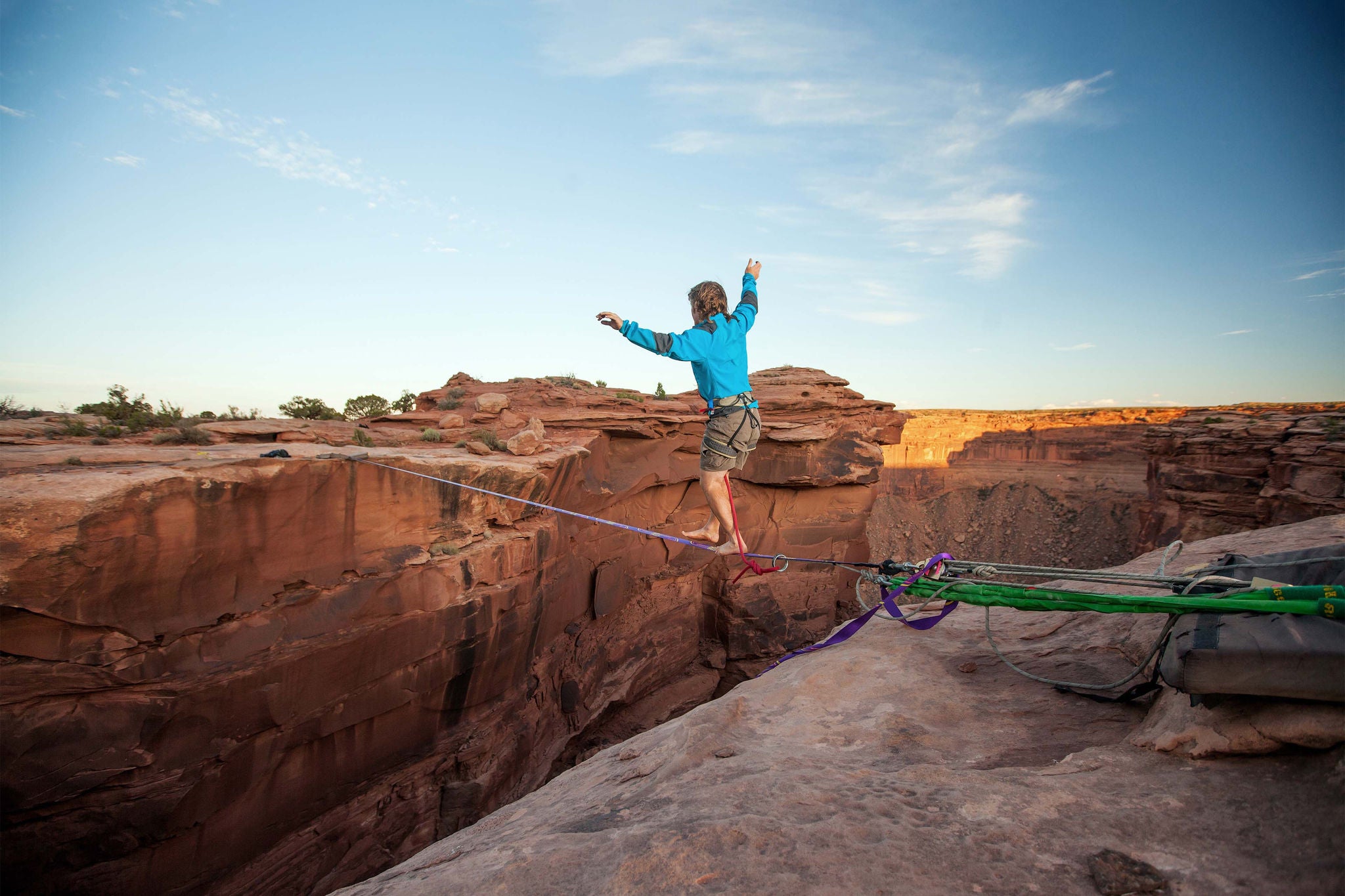 A person crossing mountain cliffs on a rope