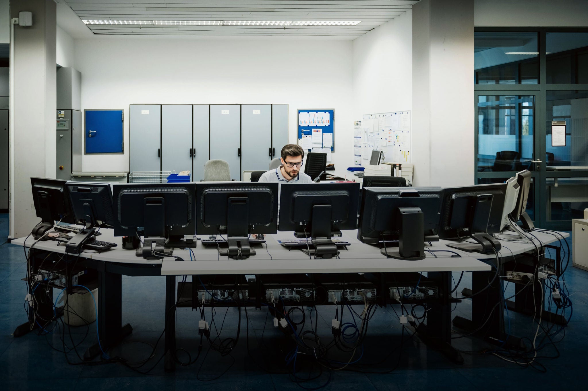 Person working on multiple screens in server room