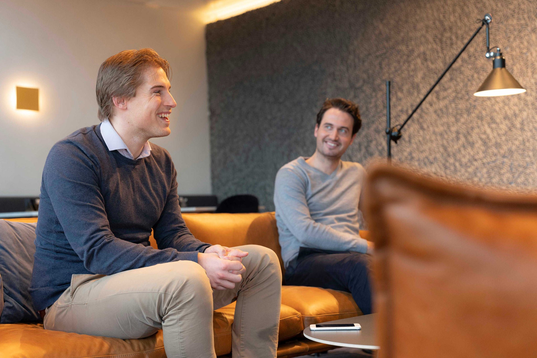 Two person are sitting on sofa and talking