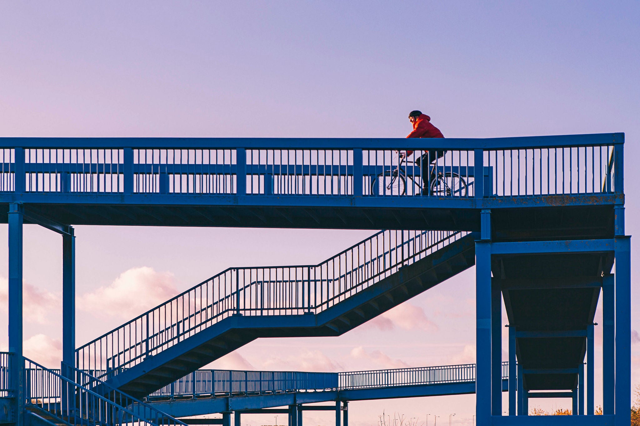 Man cycling over pedestrian bridge