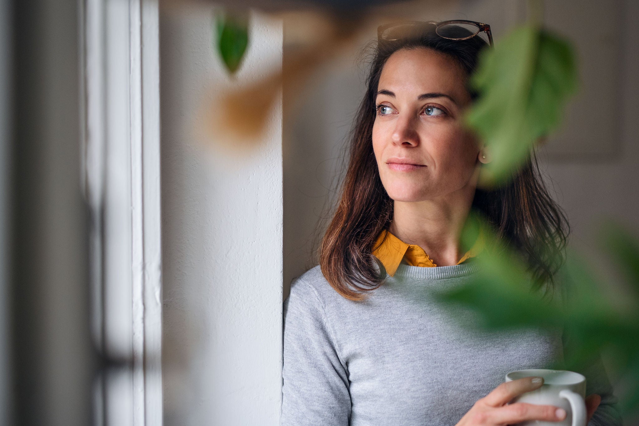 Woman drinking coffee and looking at outside