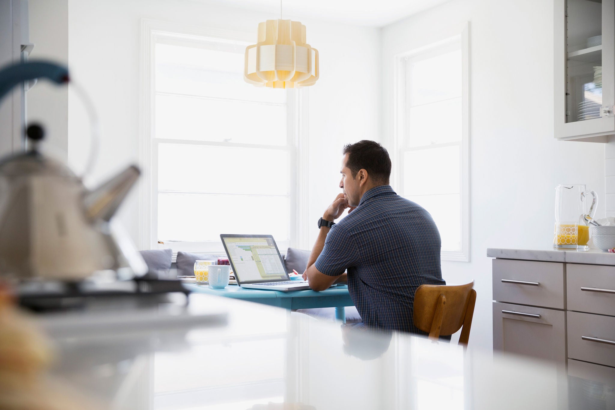 EY - Man sitting at kitchen table on laptop