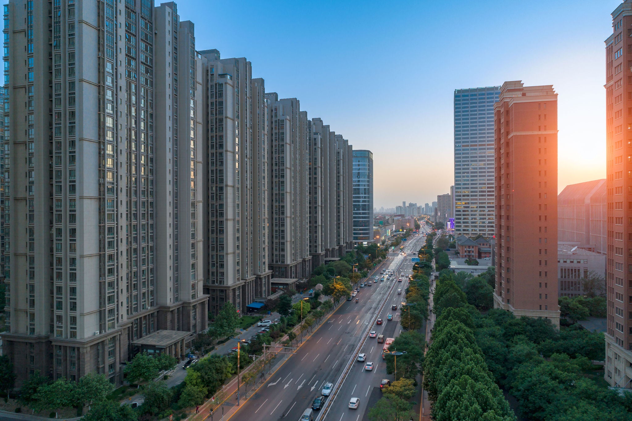 Carretera entre edificios al atardecer