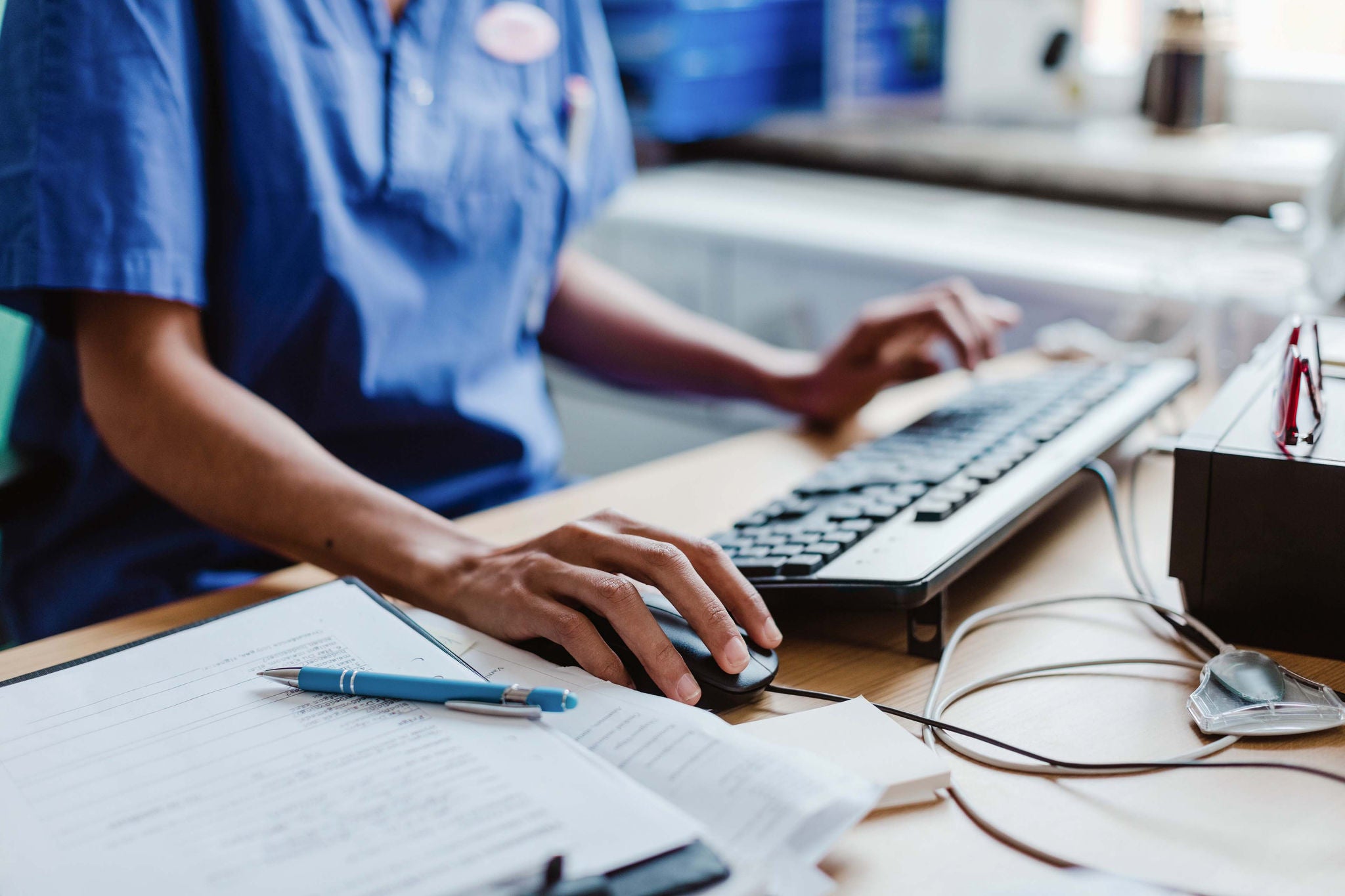 nurse using computer at desk in hospital