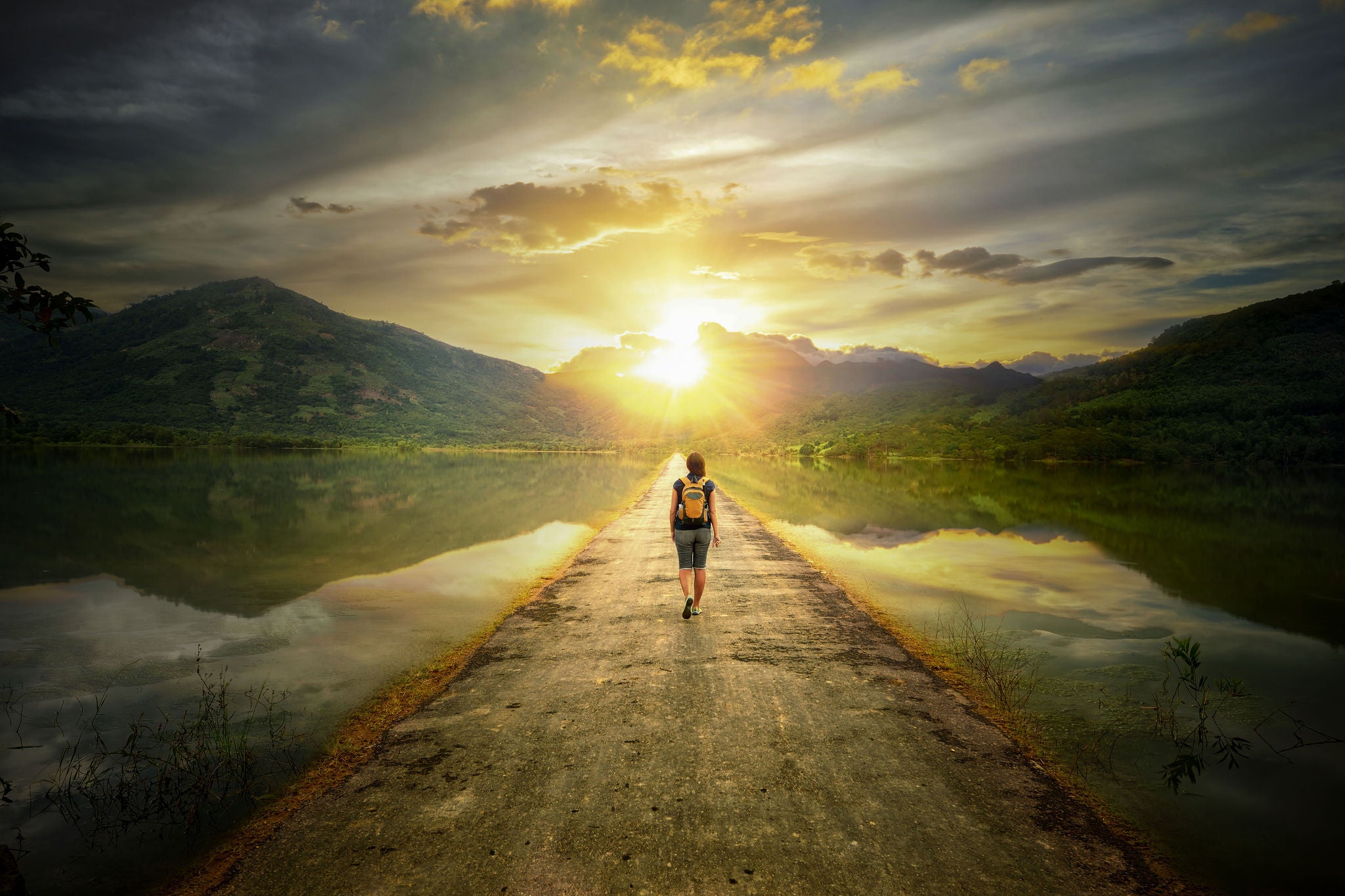 hiker walking along the road to the mountains.