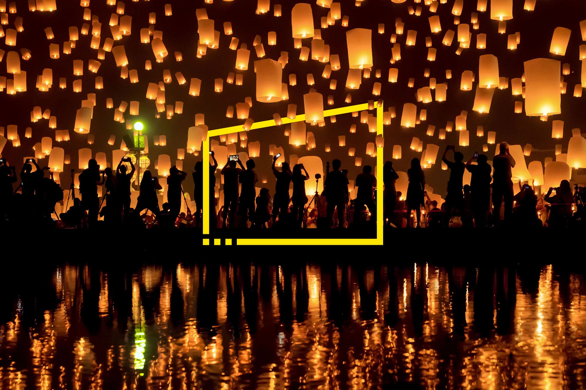 Silhouettes of people against a backdrop of paper lanterns at Yi peng festival