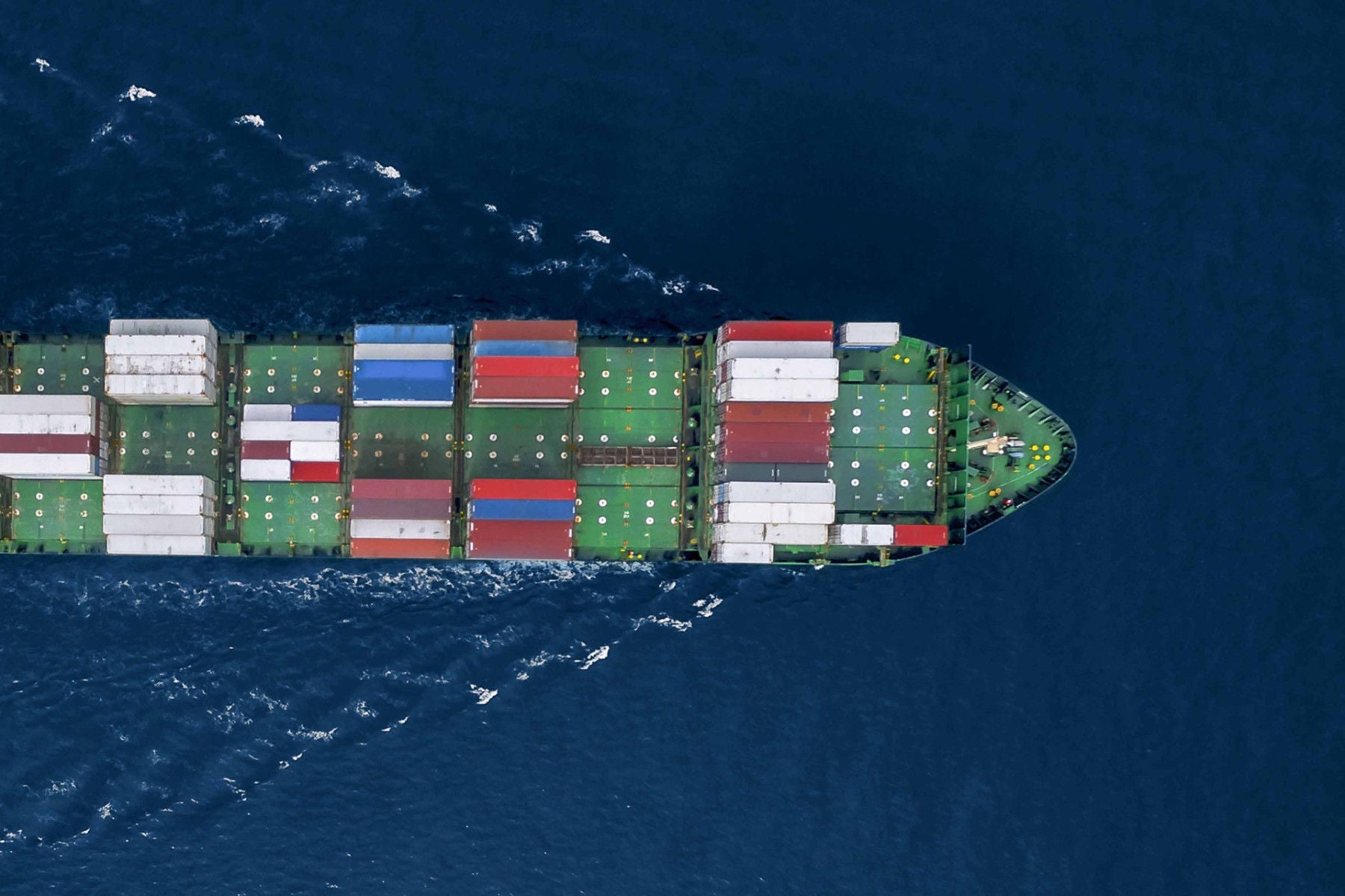 Ariel view of a boat with many colorful containers on sea