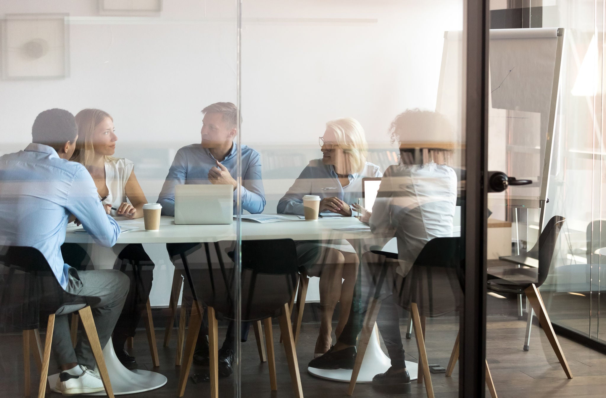 Advertising department brainstorming at modern office boardroom behind closed doors