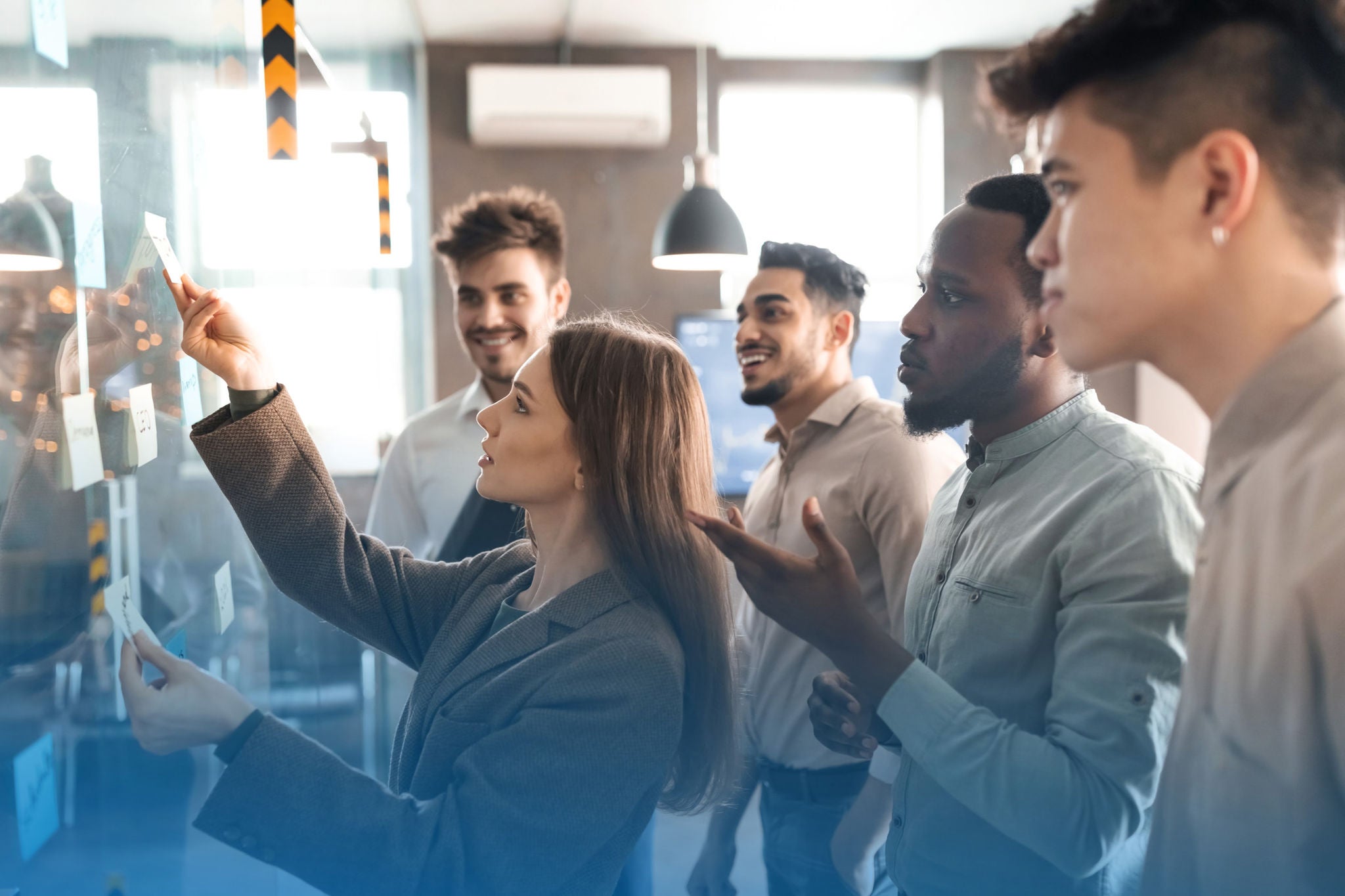 ey-group-of-people-looking-at-notes-on-clear-wall