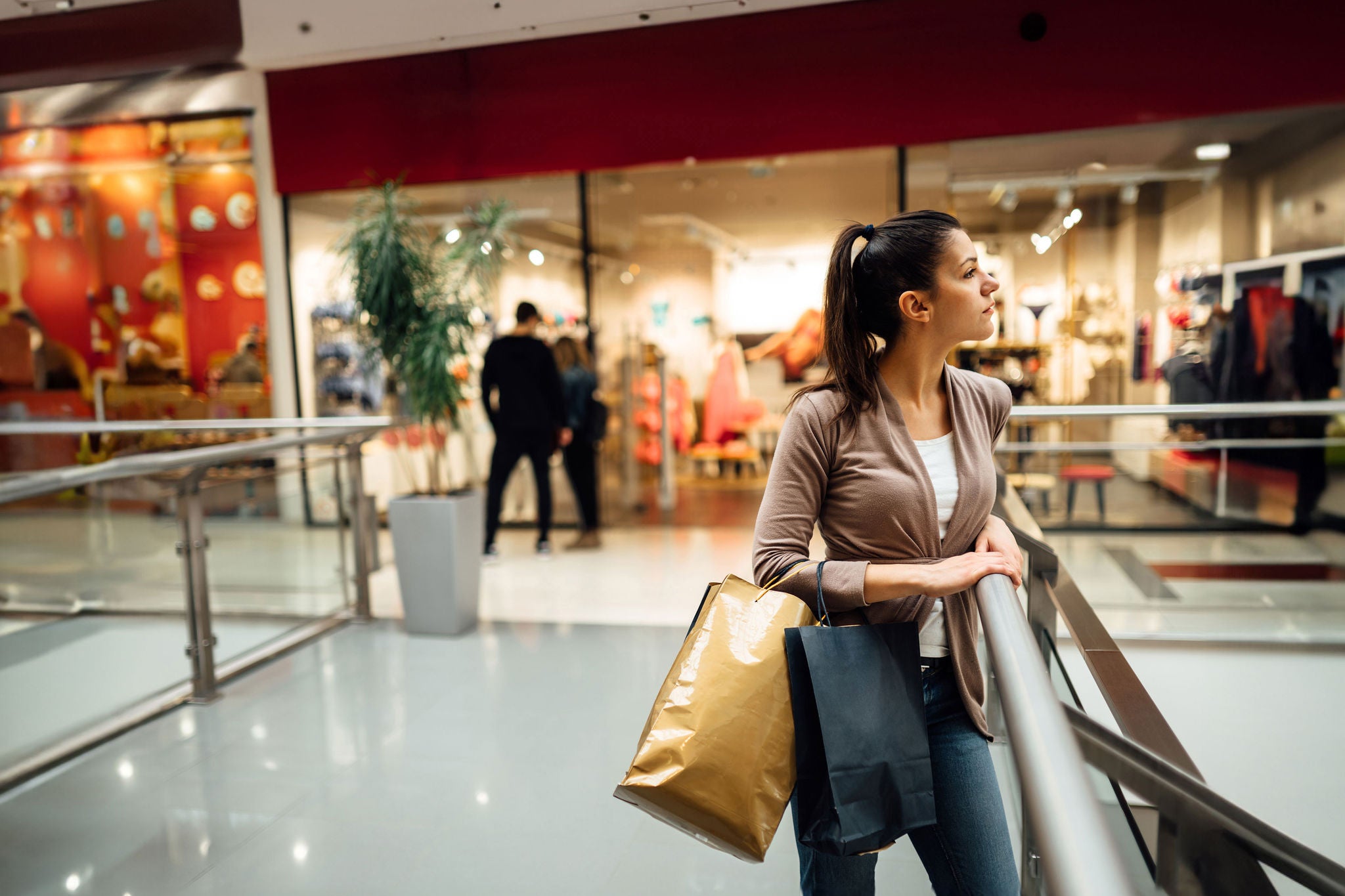 Disappointed shoppingholic woman in shopping mall.Buying in designer store.Wardrobe shopping.Hoby buyer.Weakness for clothes.Image makeover