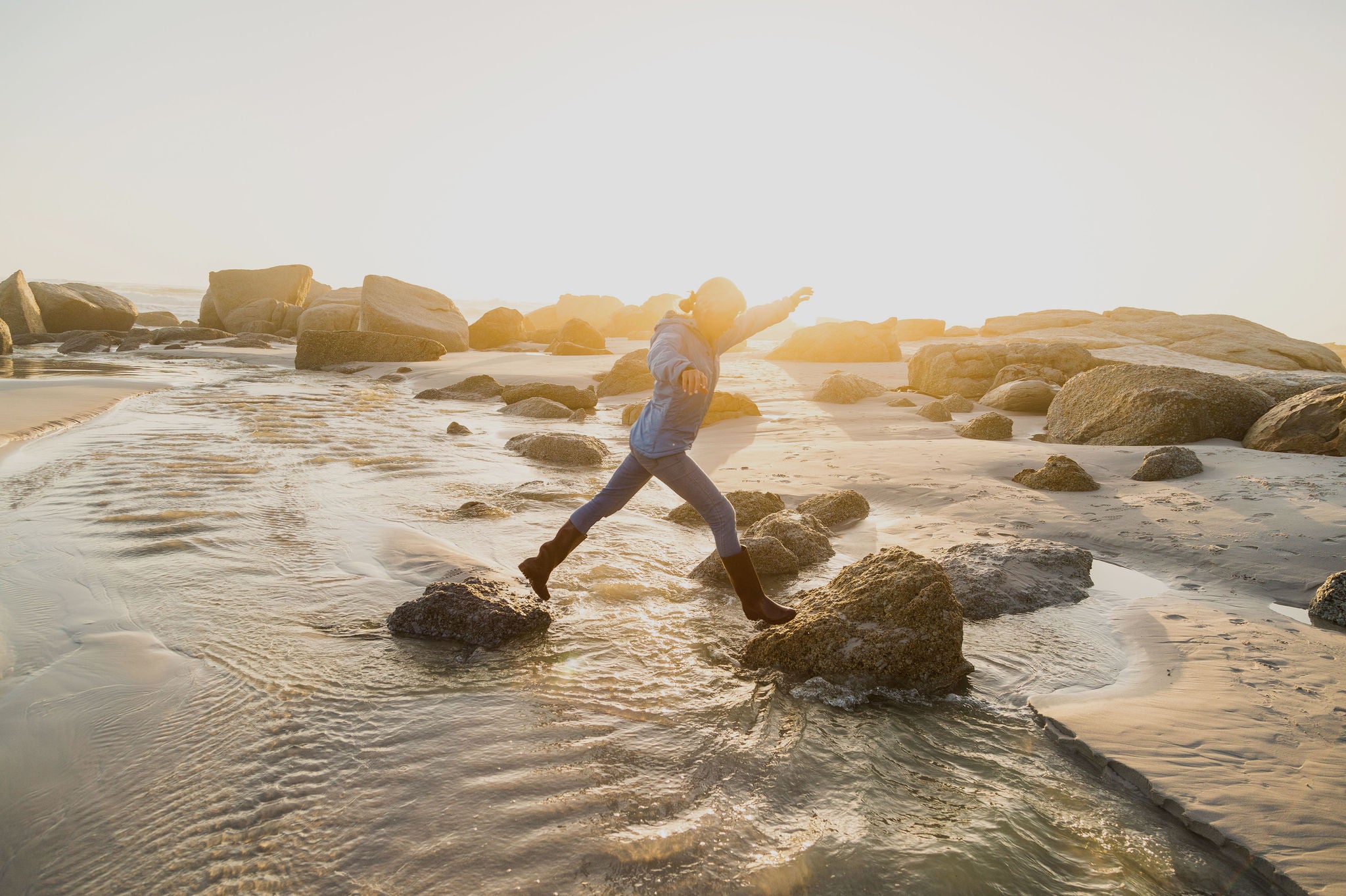 Women jumping from one stone to another