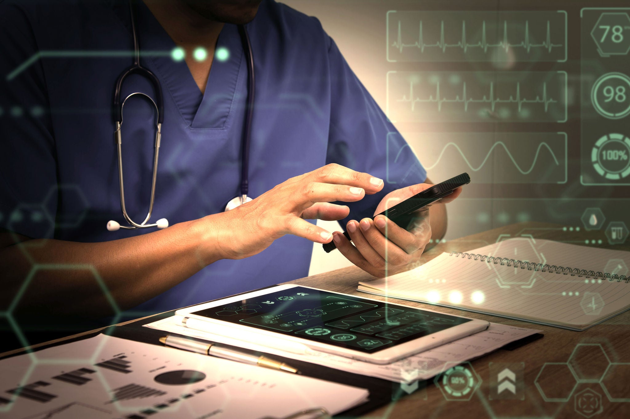 Smart medicine doctor working with computer notebook and digital tablet at desk in the hospital. Medical concept, futuristic virtual interface screen