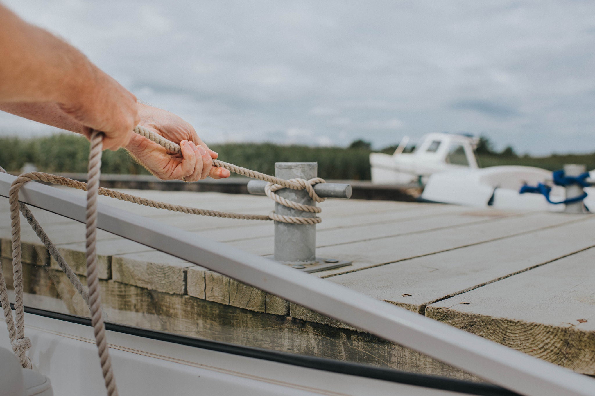 Man securing a rope to a boat cleat