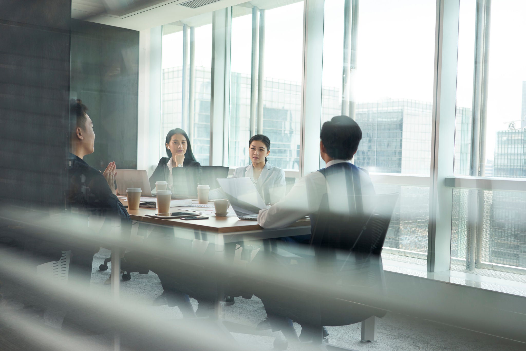 group of asian corporate executives meeting in conference room in office