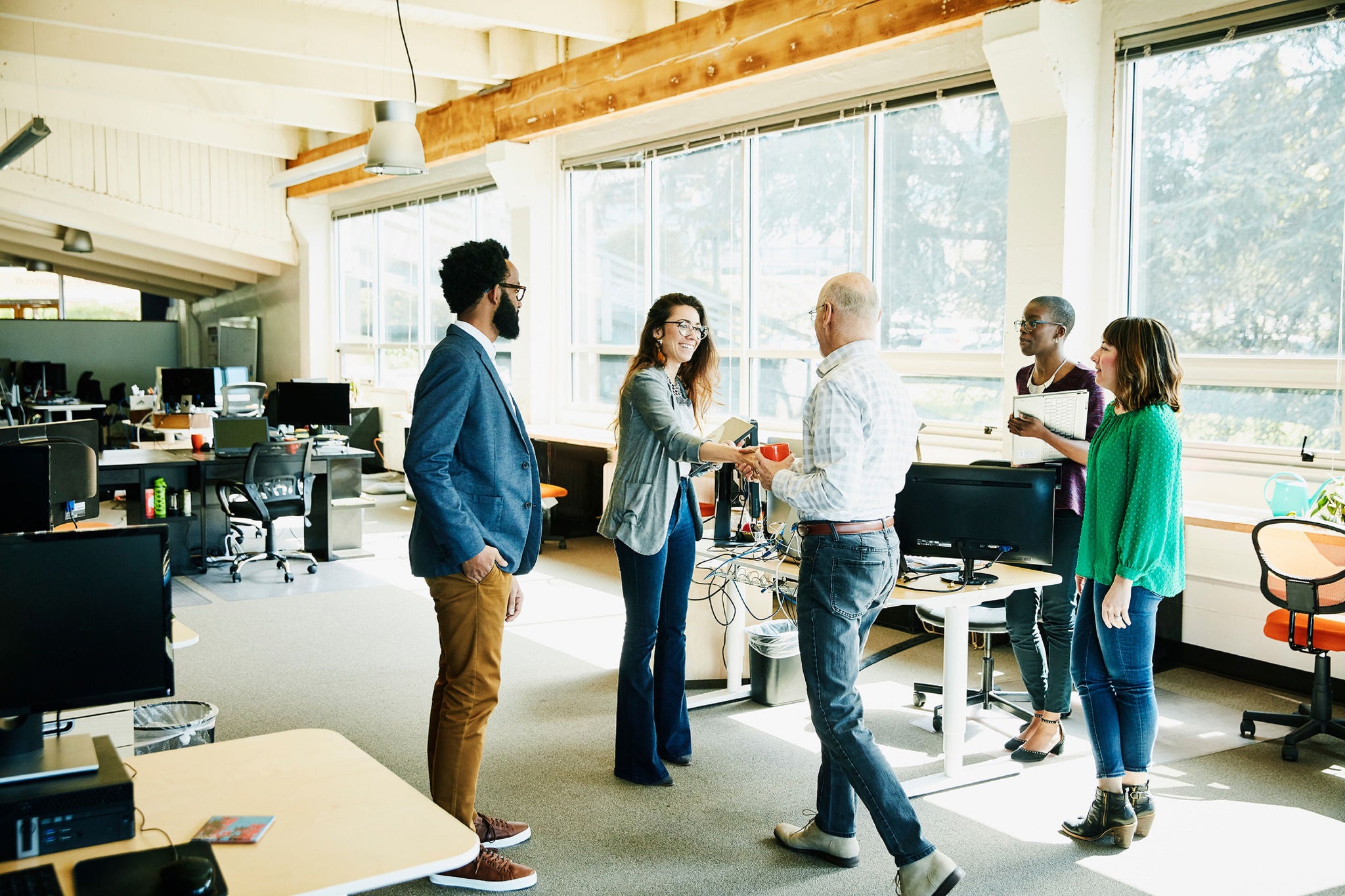 Businesswoman shaking hands with client before meeting in start up office