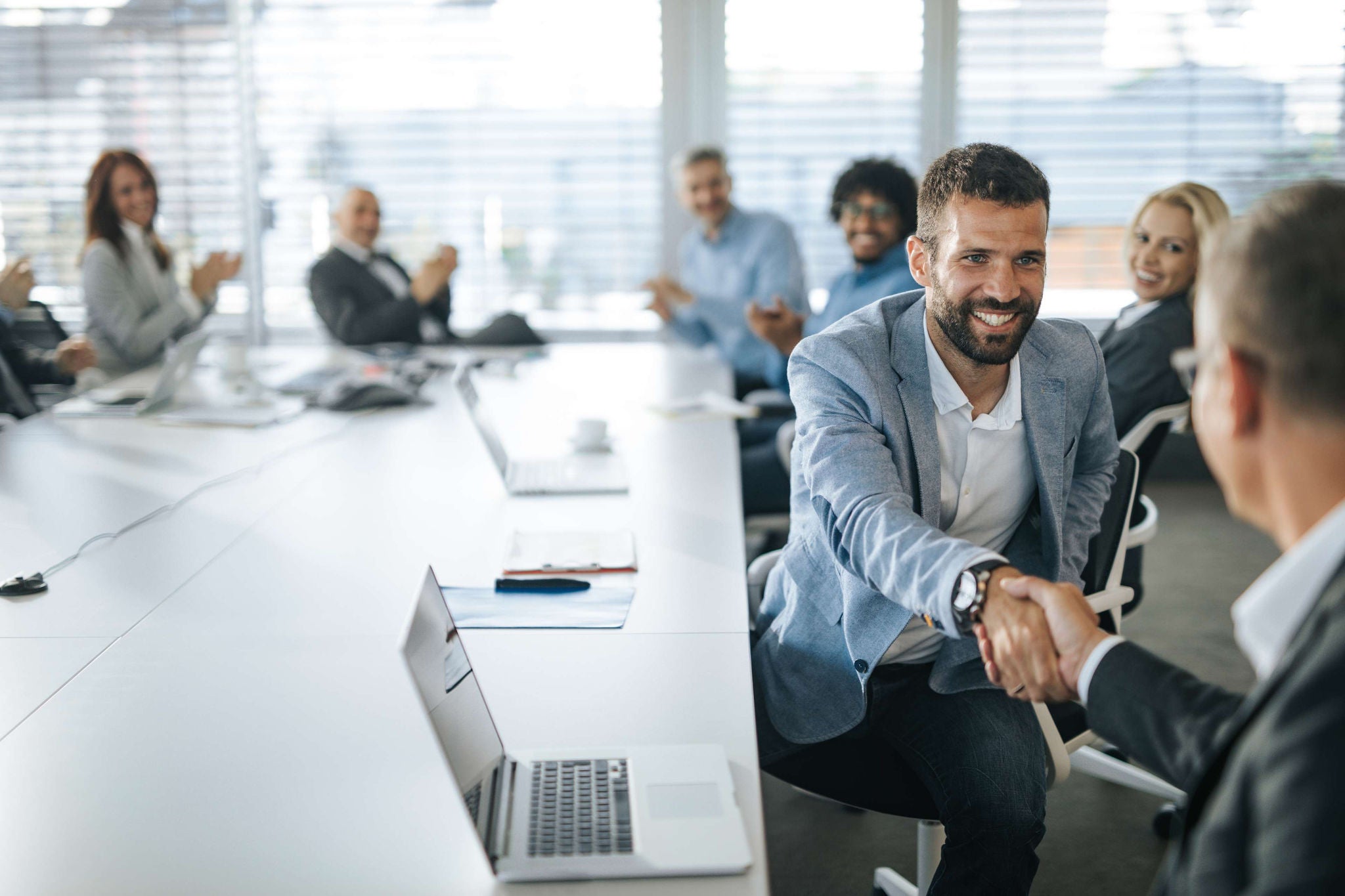 Happy businessman shaking hands with his colleague on a meeting in the office.