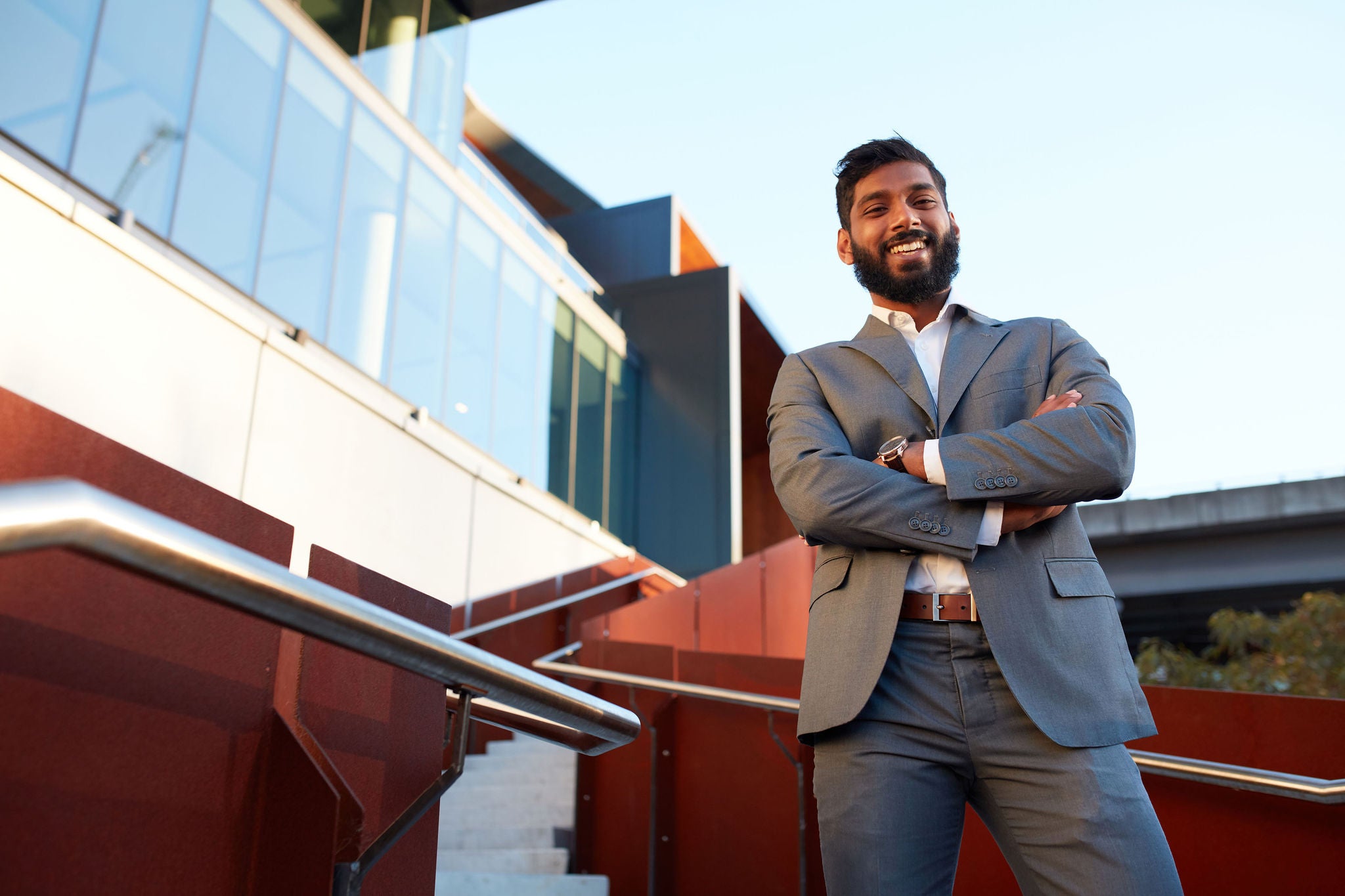 Smiling Indian businessman with open collar outdoors in city