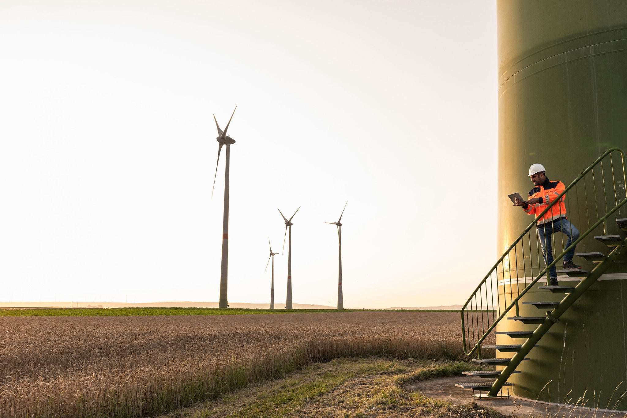 Male Inspector Using Digital Tablet While Standing on Wind Turbine Staircase