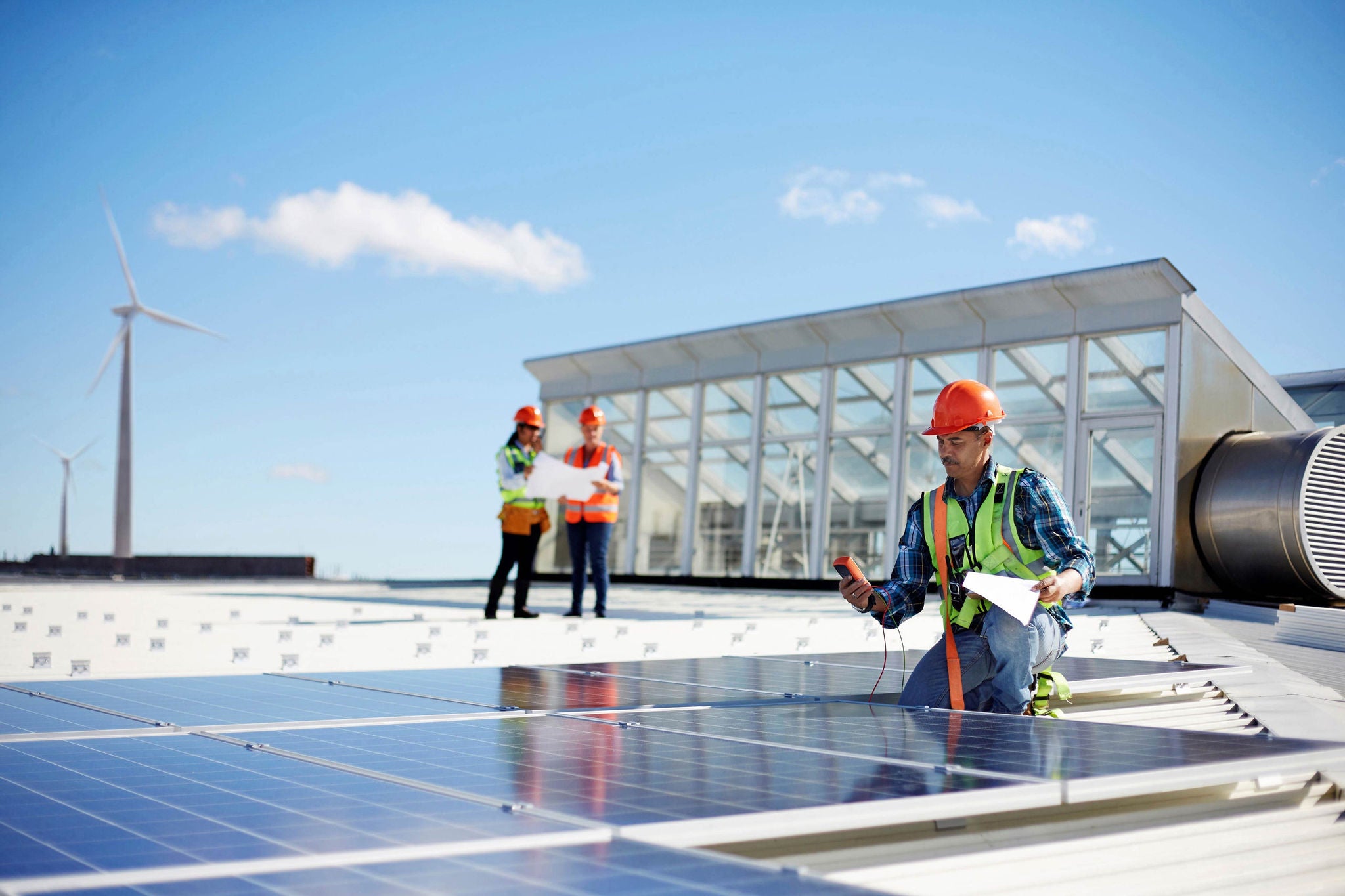 Energy engineers working on solar panels and wind turbines