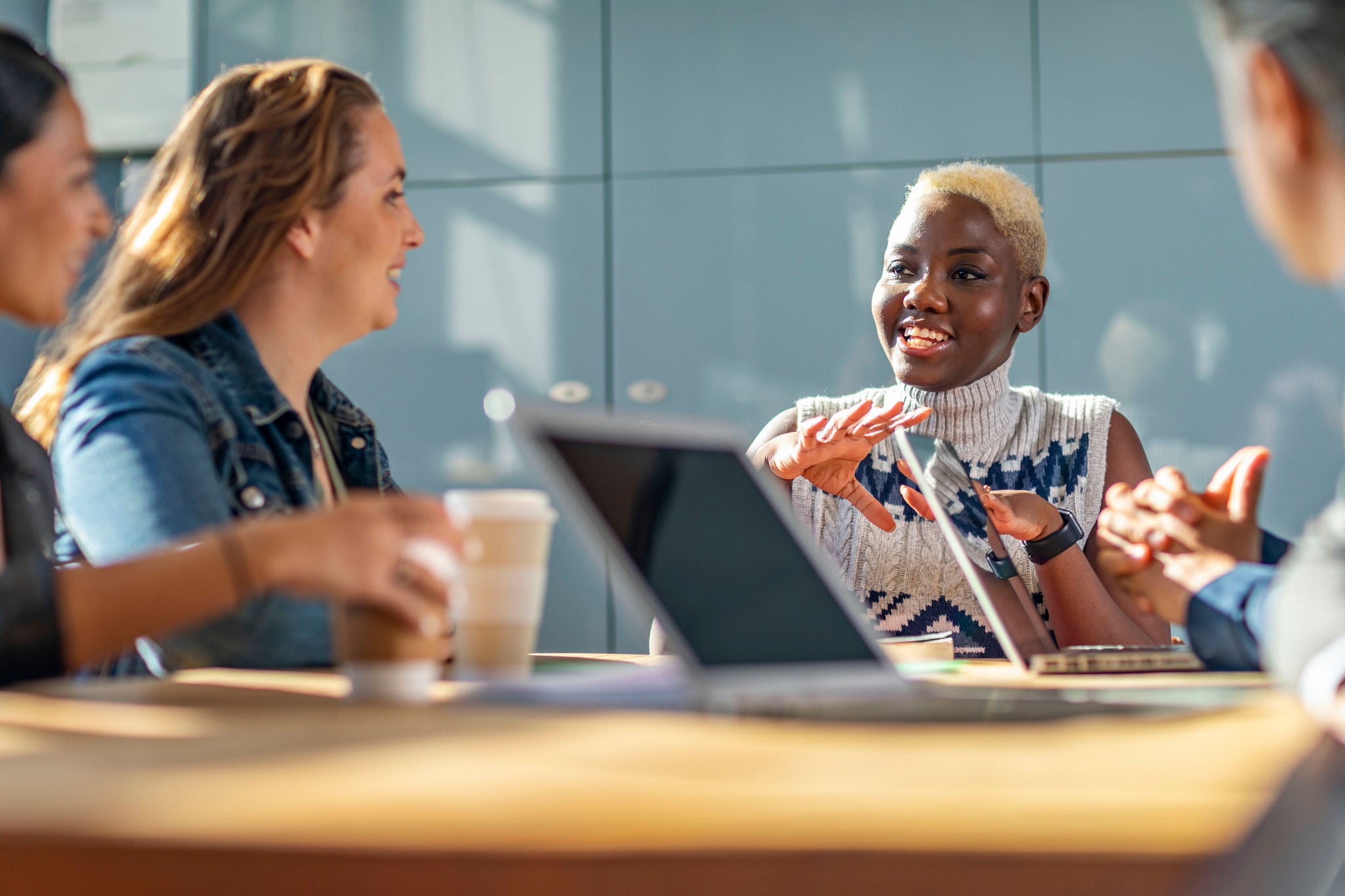 Cheerful woman in her 20s in business meeting with colleagues, teamwork, discussion, connection