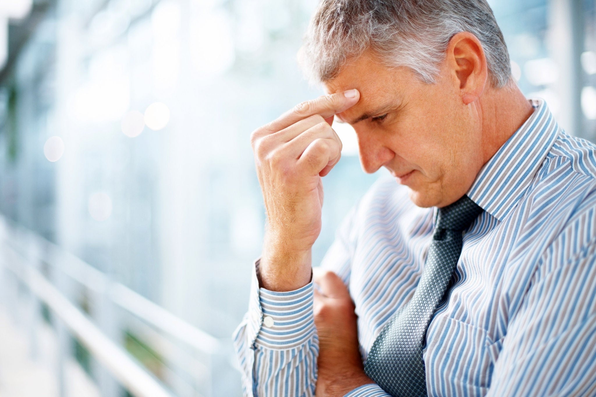 Ey man pinching his forehead indicating headache