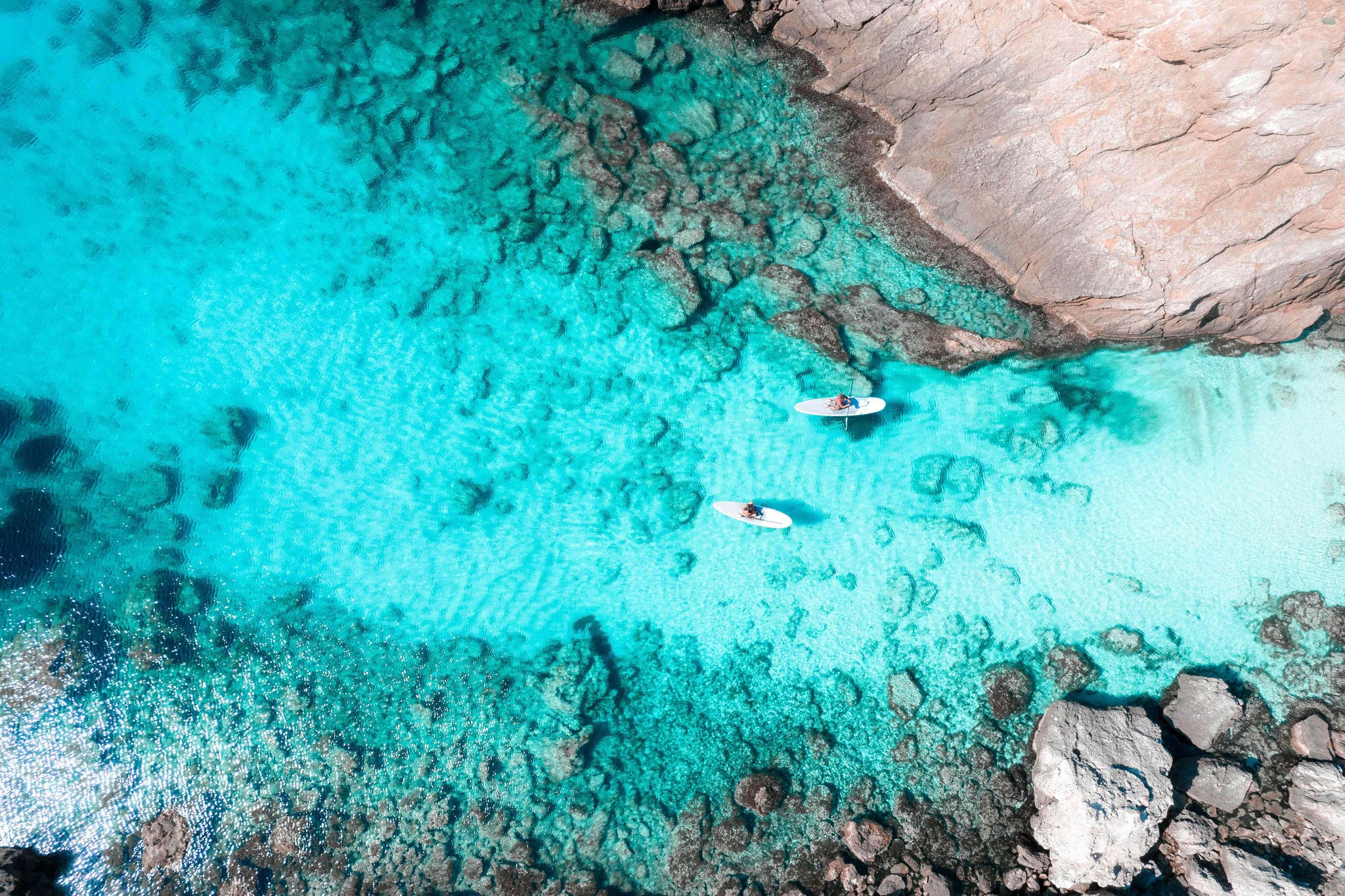 Drone picture of paddleboarders on beach in Menorca island