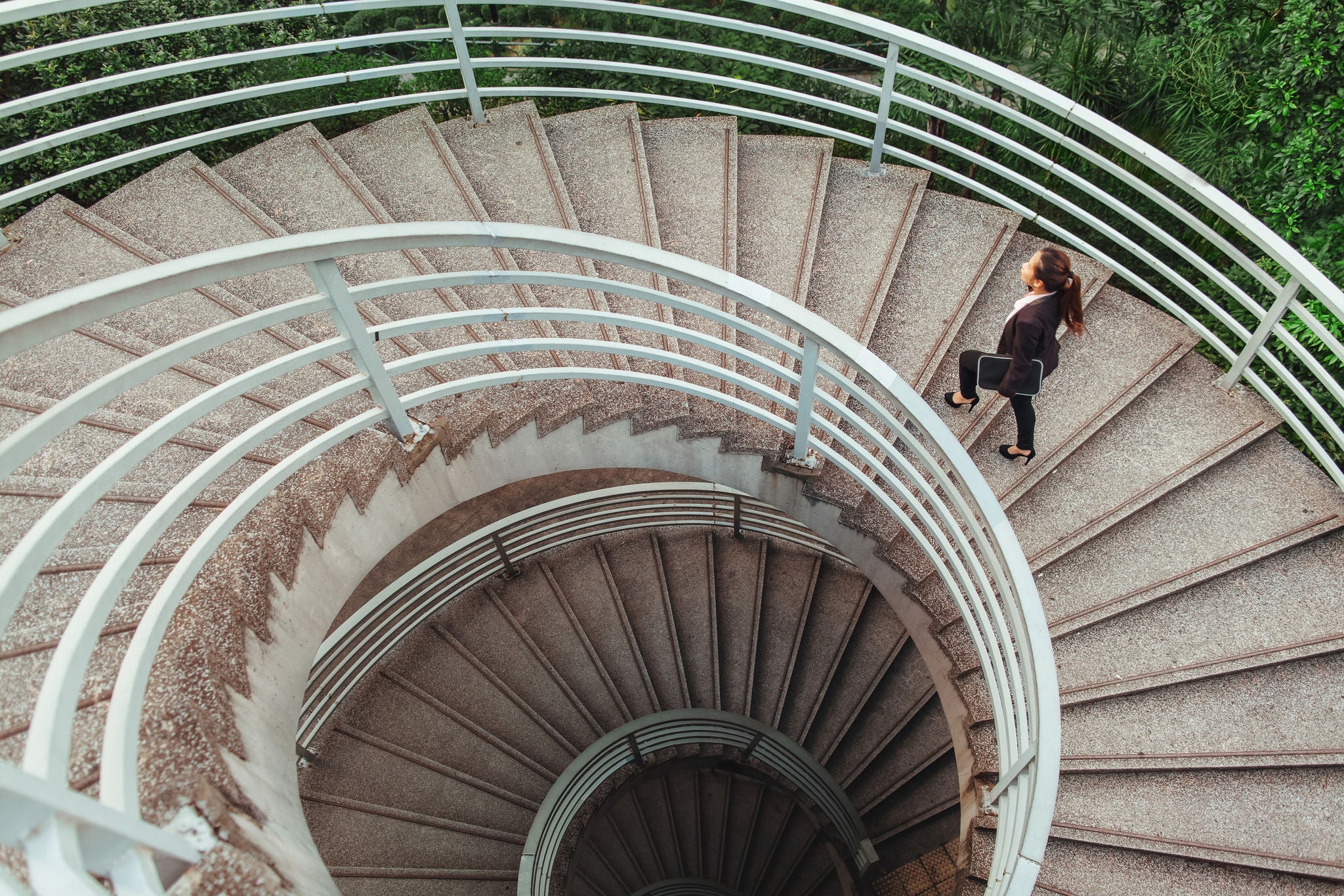 Business woman walking on spiral staircase in Hong Kong