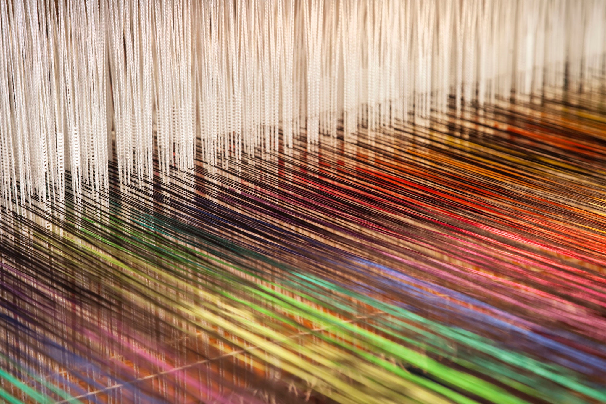 Closeup of a loom weaving colorful fabric