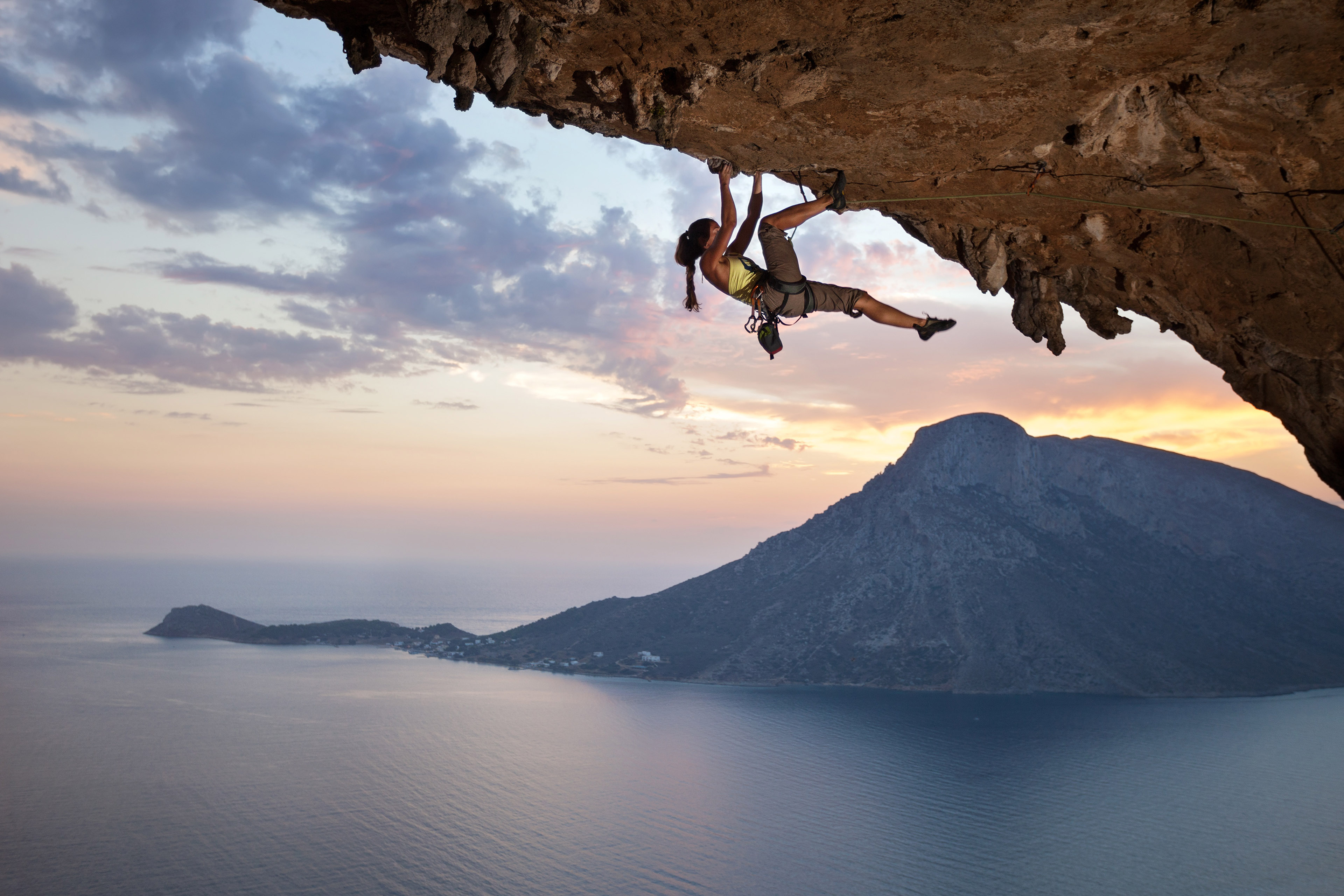 Women trying to rock climber at sunset