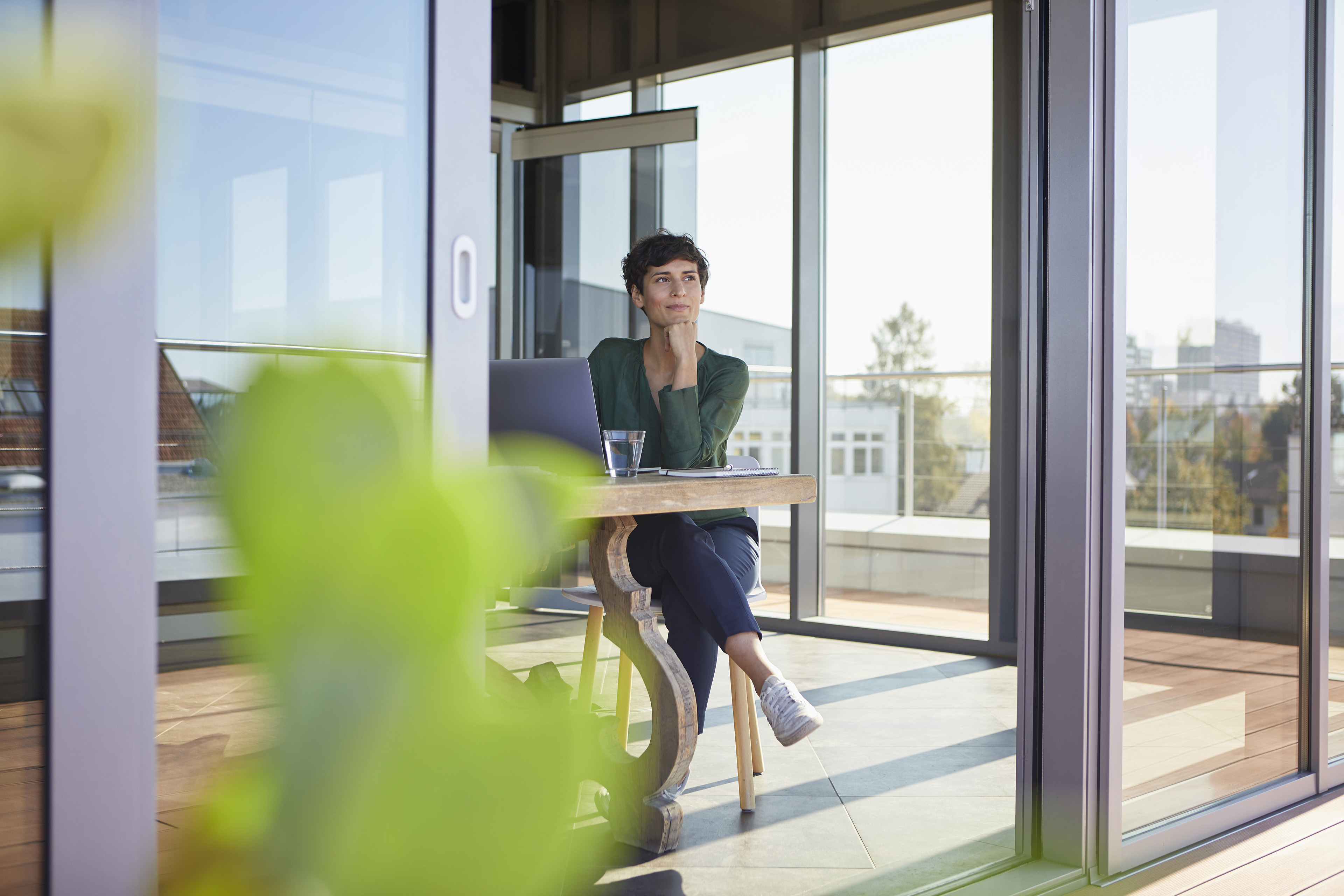 Smiling businesswoman sitting at table with laptop