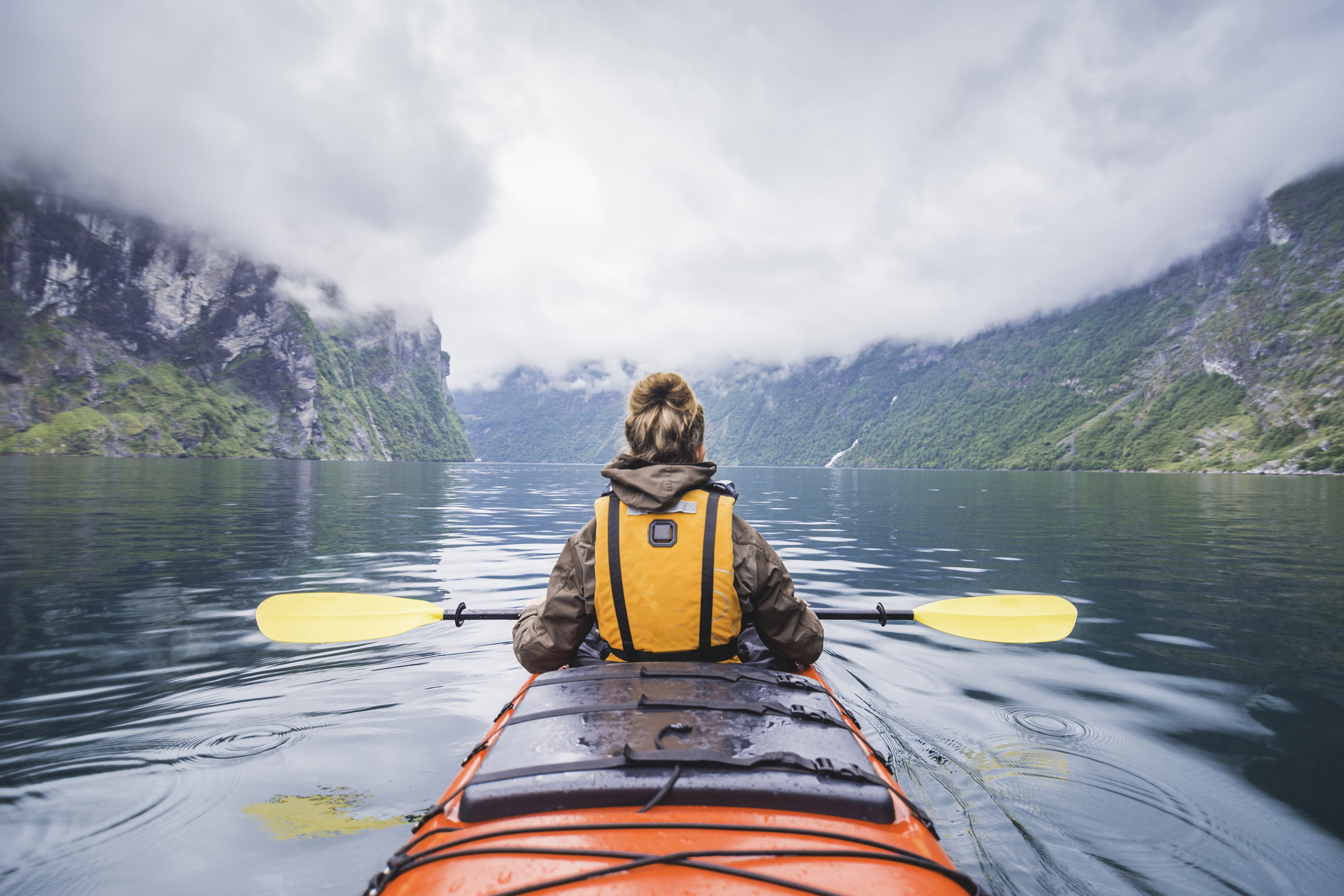 Kvinde i kajak på fjord i Norge