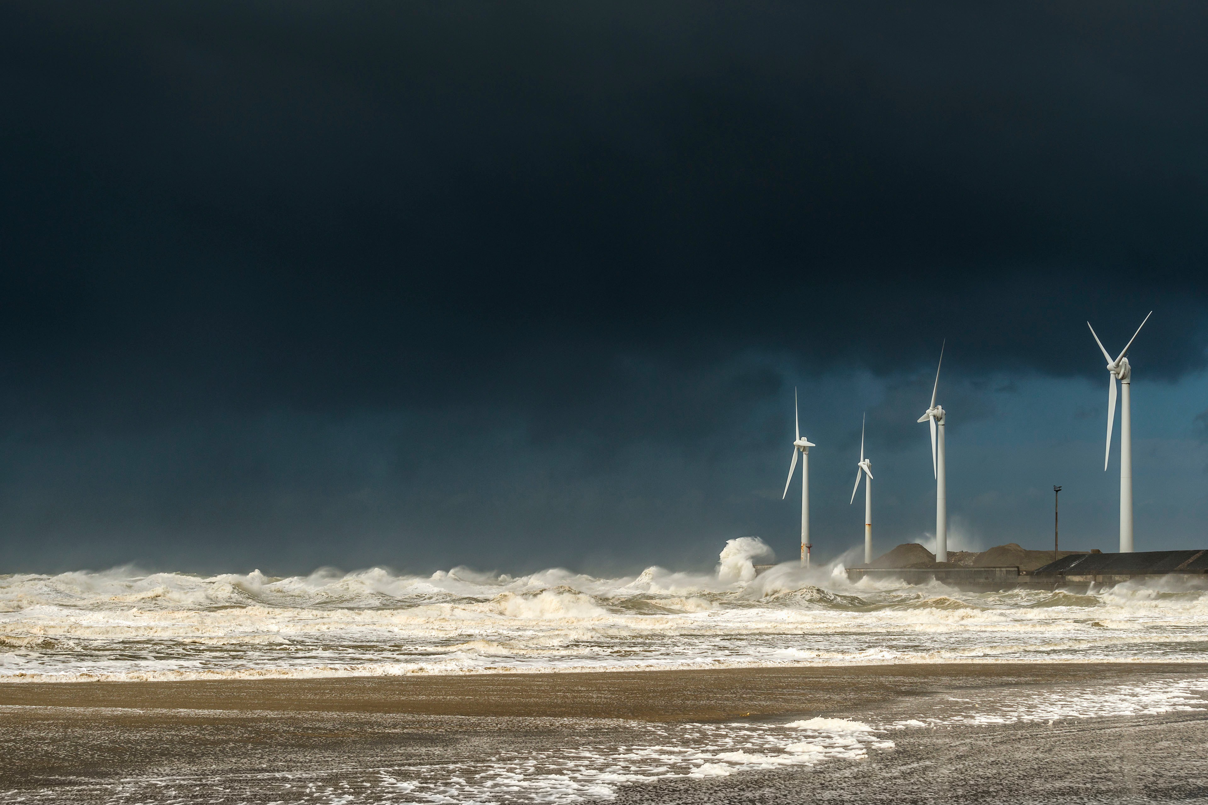 Fire vindmøller midt i voldsomme stormbølger og skyer