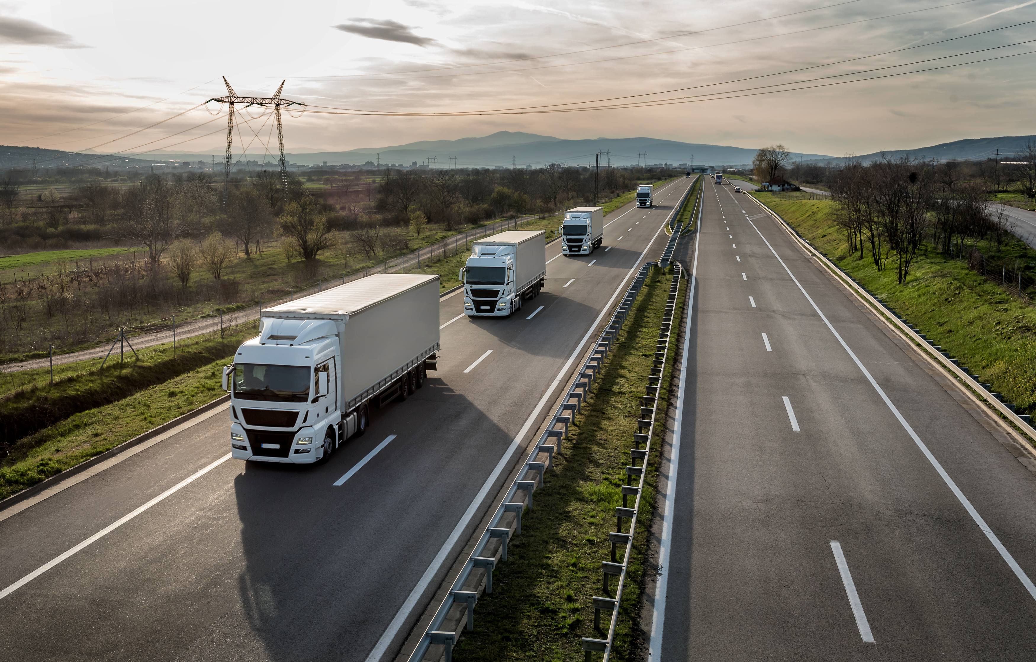 Konvoi von Lastwagen in einer Reihe auf einer Autobahn