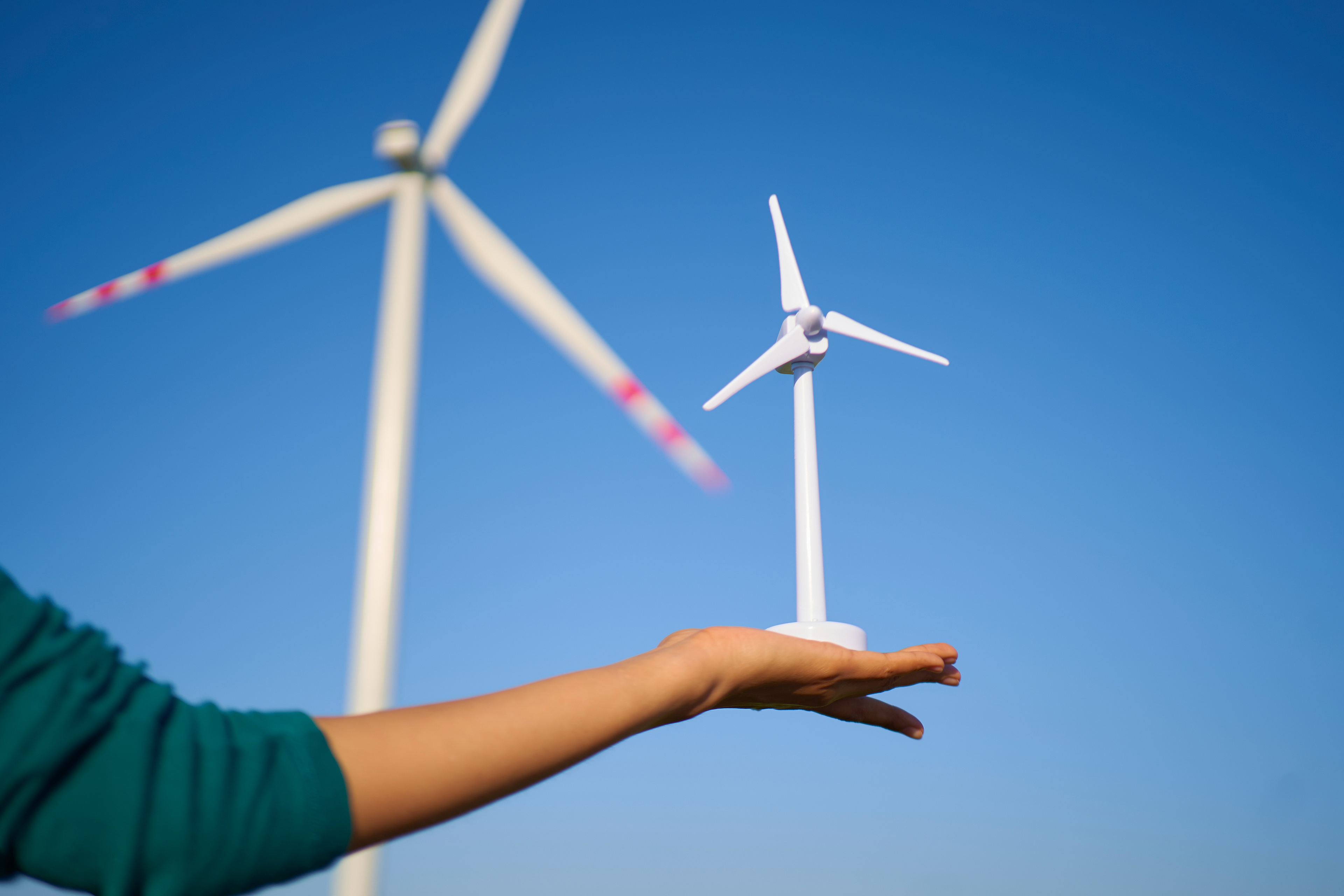 A hand Holding Wind Turbine Prototype Model Miniature