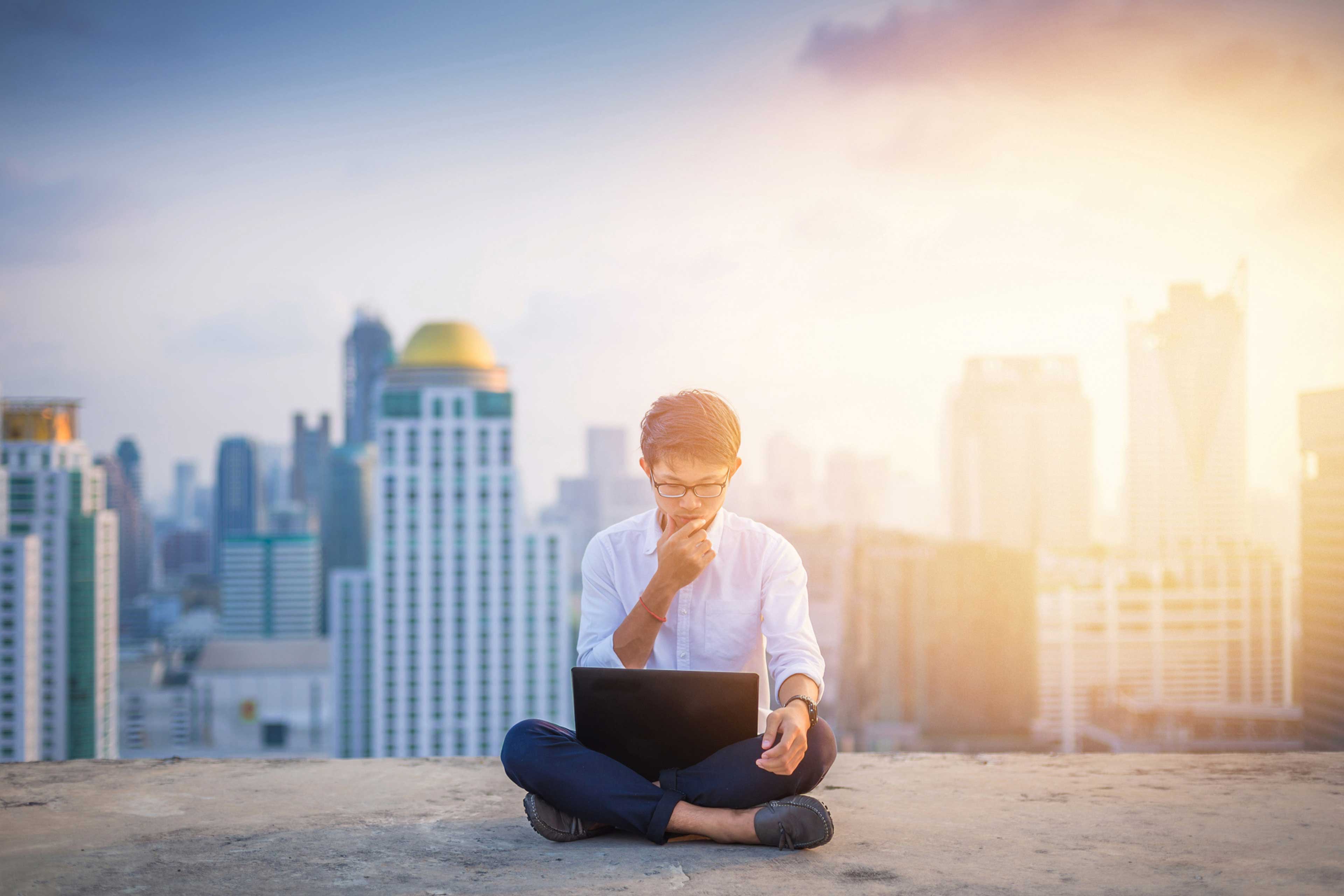 Ein Mann mit Laptop in der Stadt Hintergrund