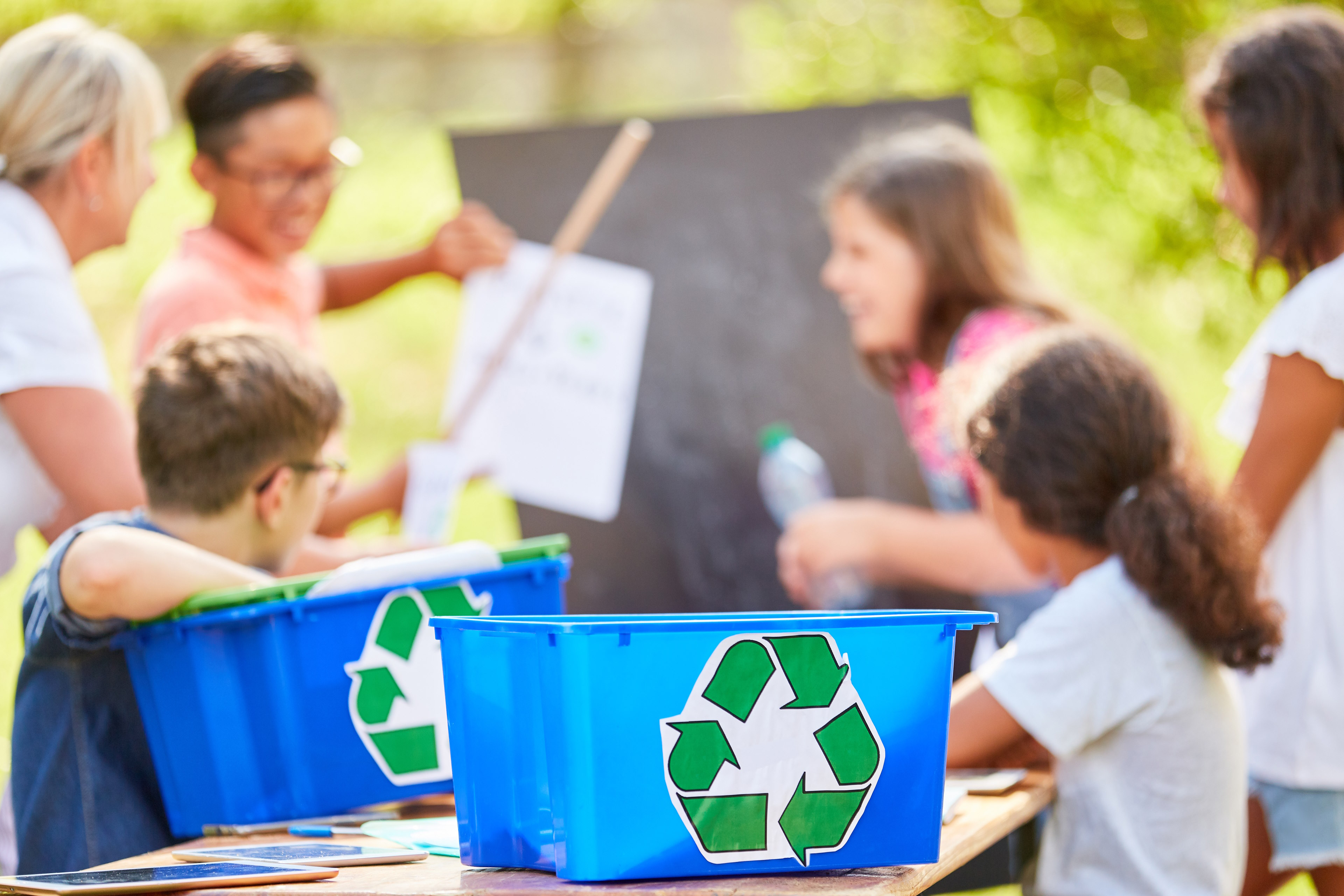 Two kids learning how to recycle process