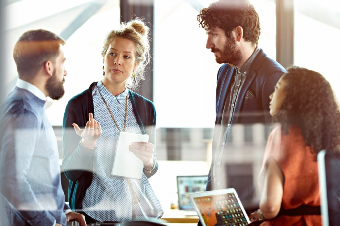 Team of two women and two men discussing in a business setting