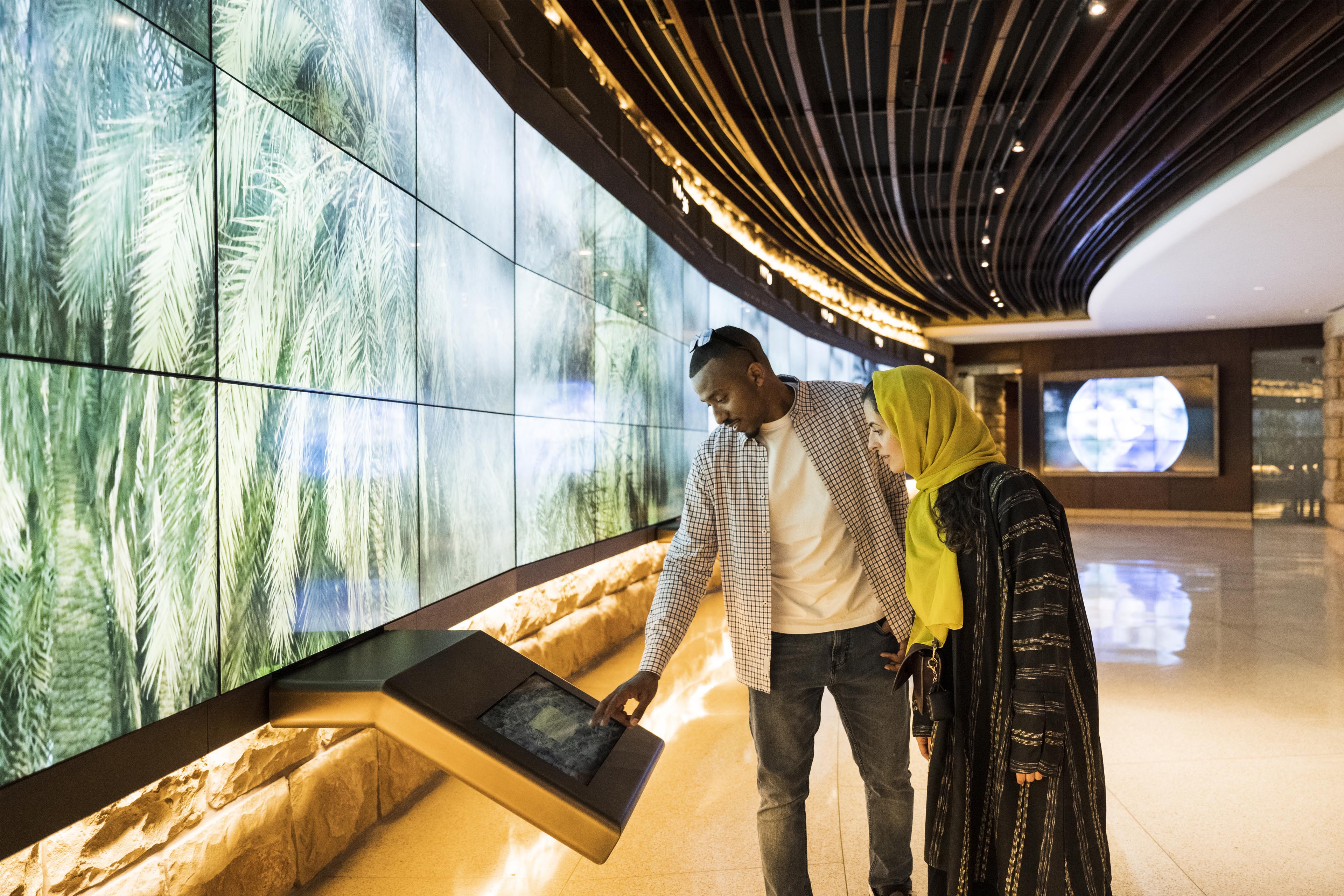 Side view of mid adult couple enjoying interactive learning experience in UNESCO World Heritage Site near Riyadh.