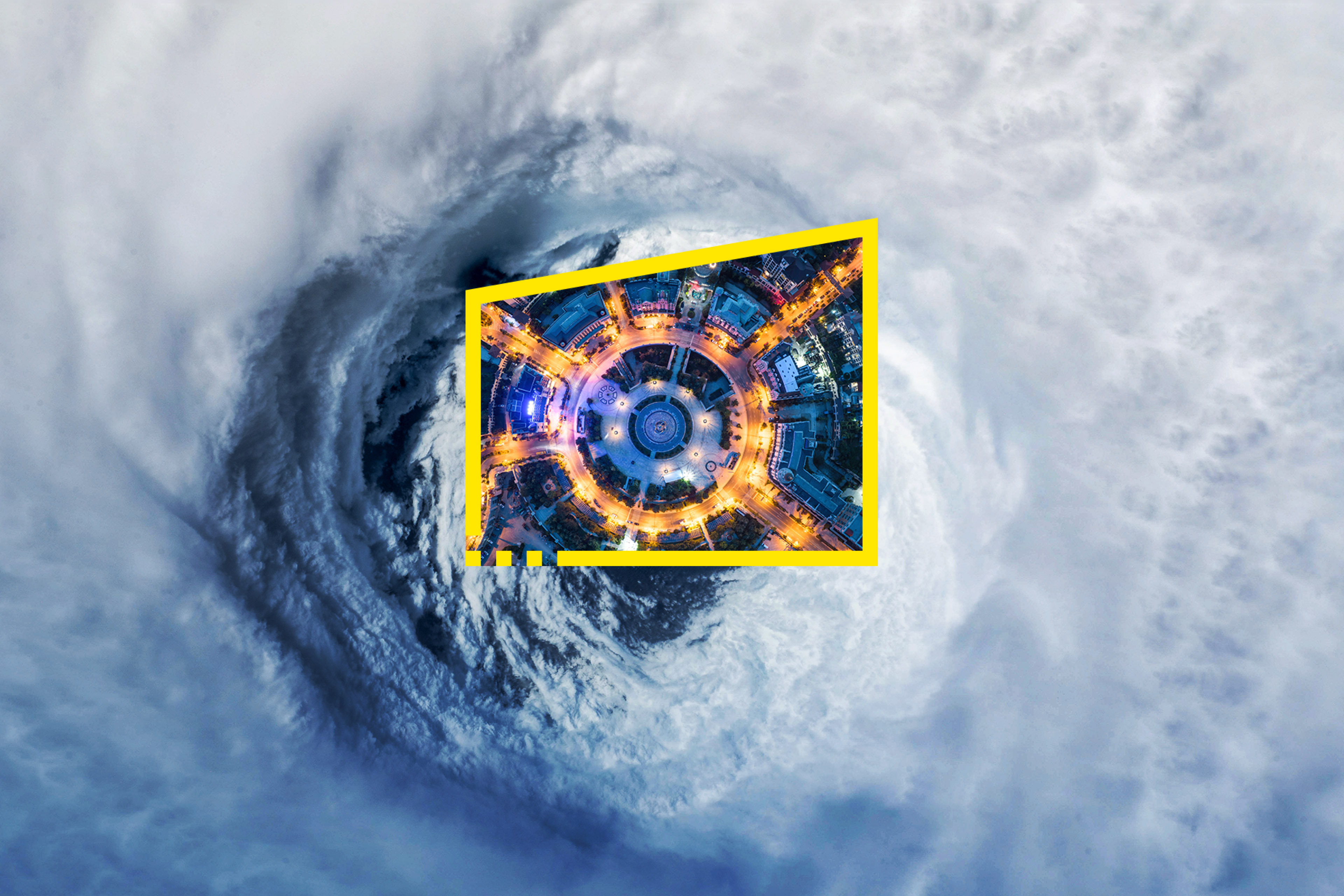 City lights within a yellow frame over a hurricane's eye.