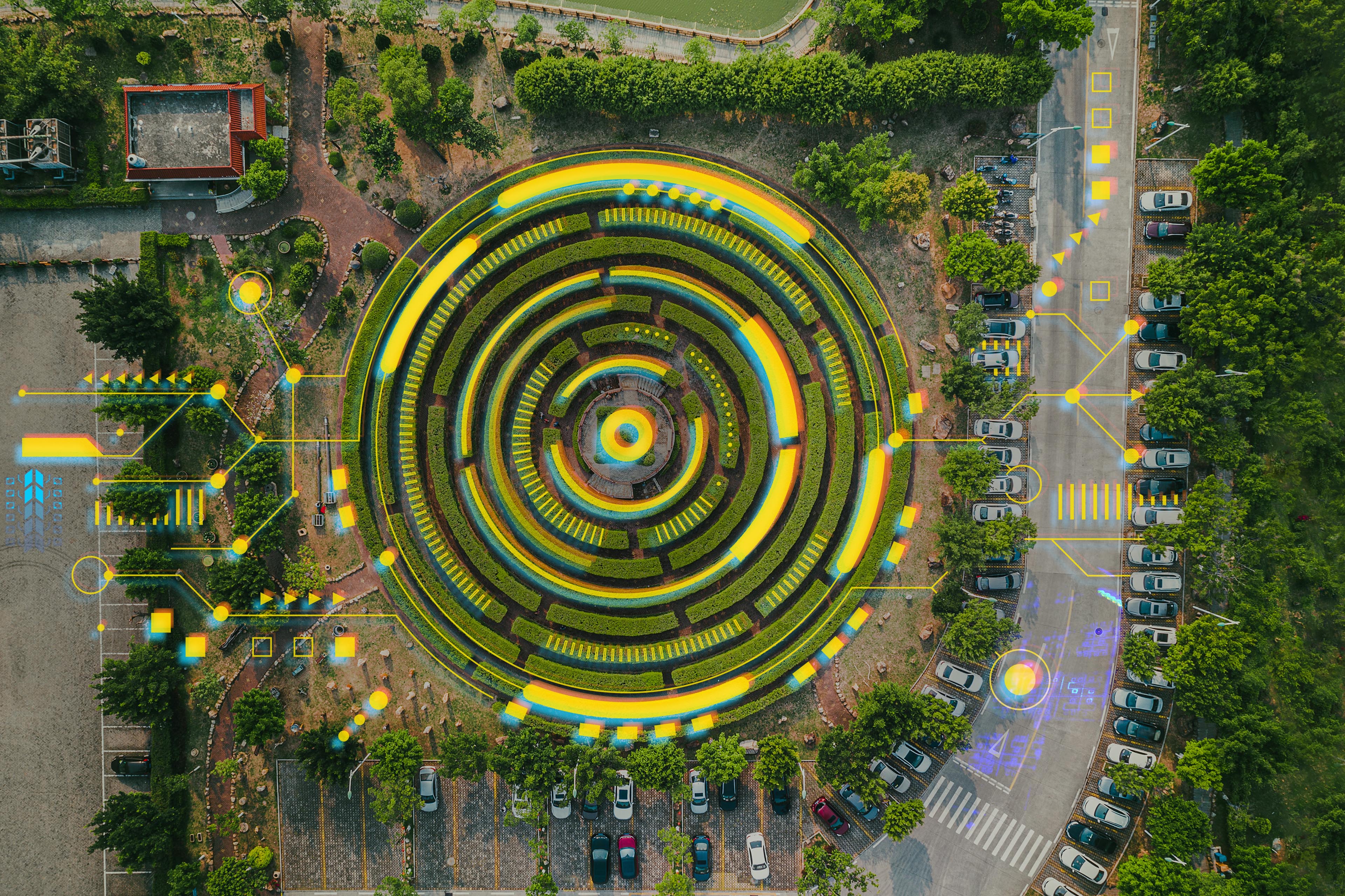 Aerial view of a circular garden maze and green pavilion