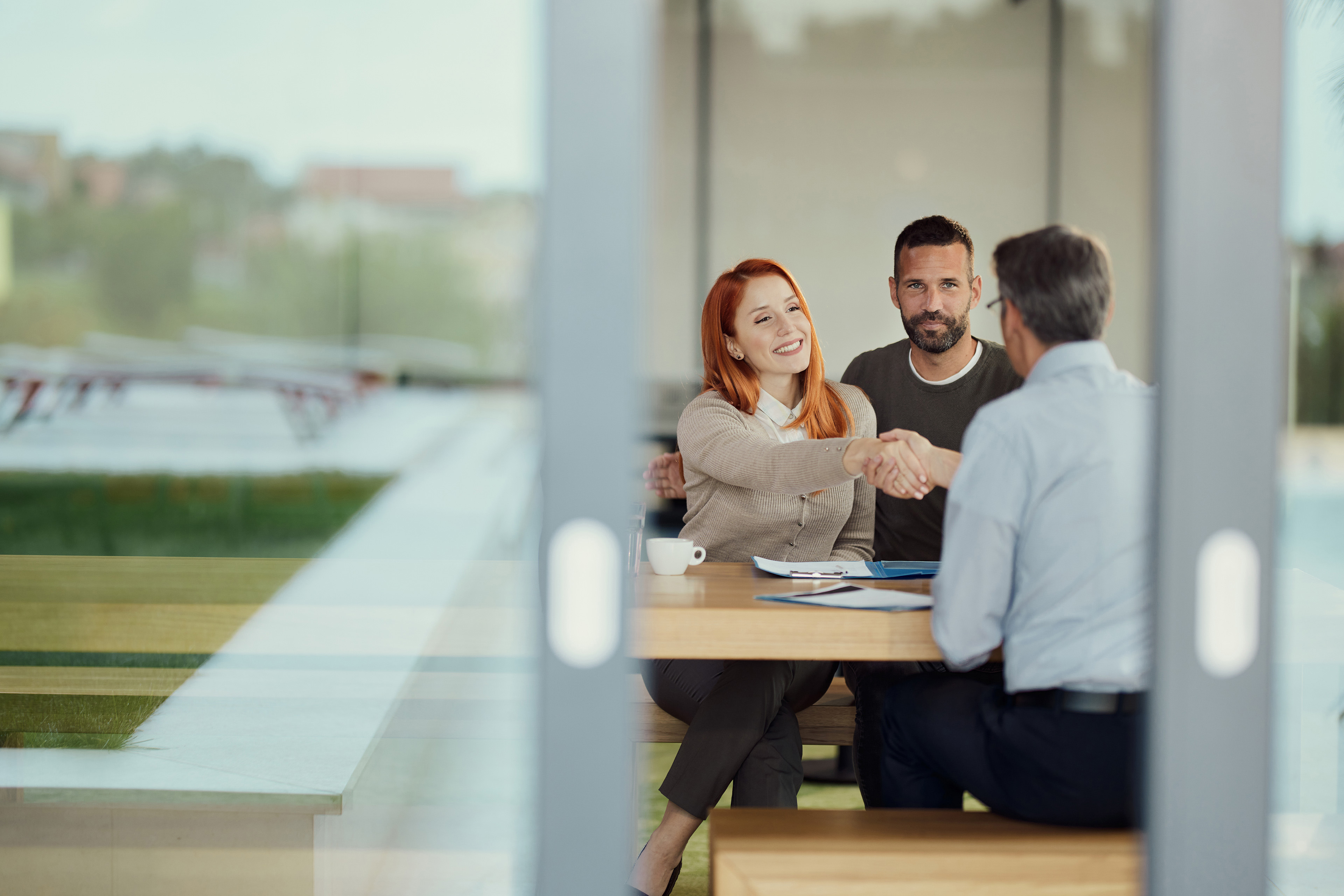 Happy couple came to an agreement with insurance agent in the office