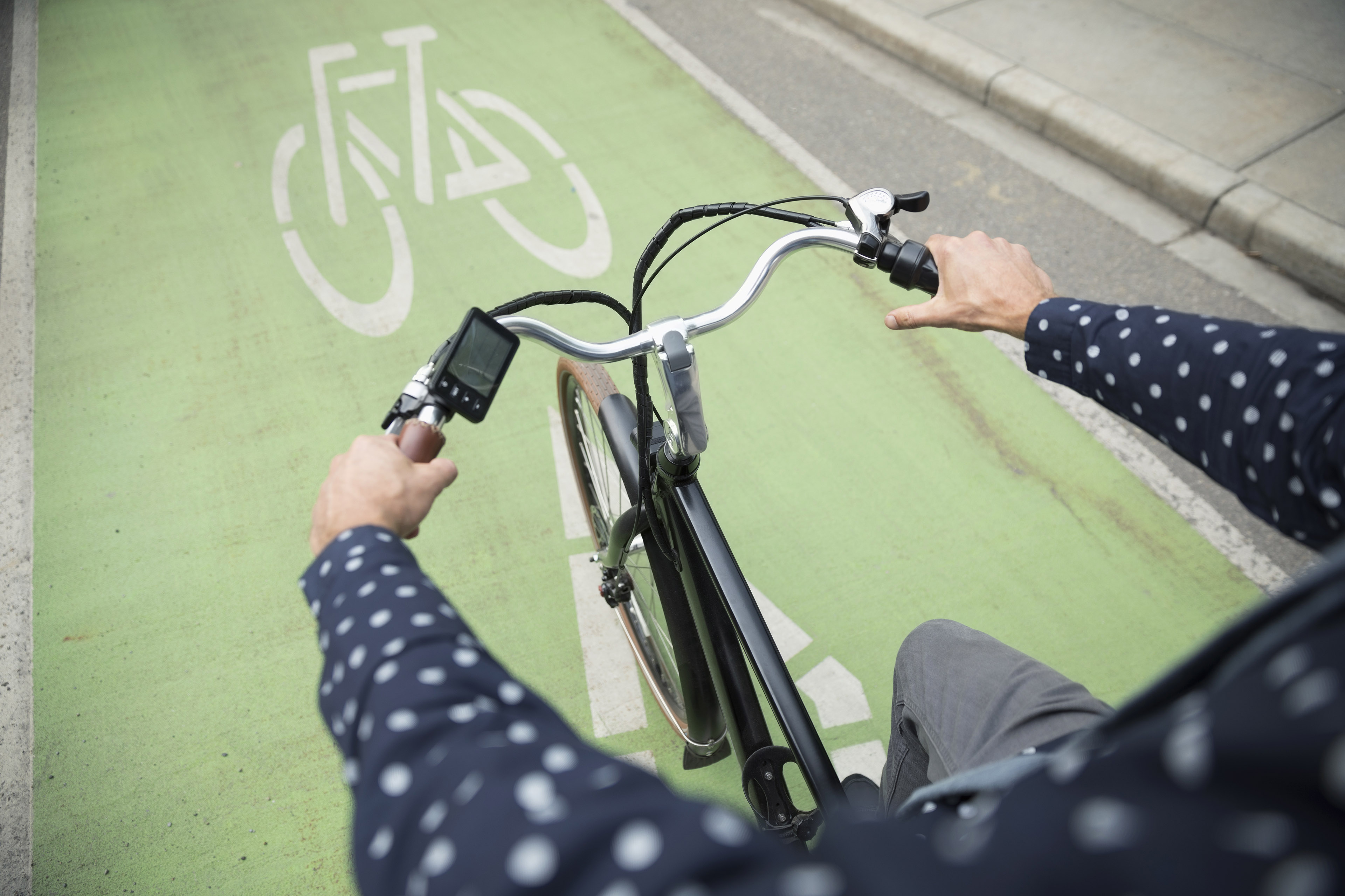 Businessman commuter riding bicycle in urban bike lane