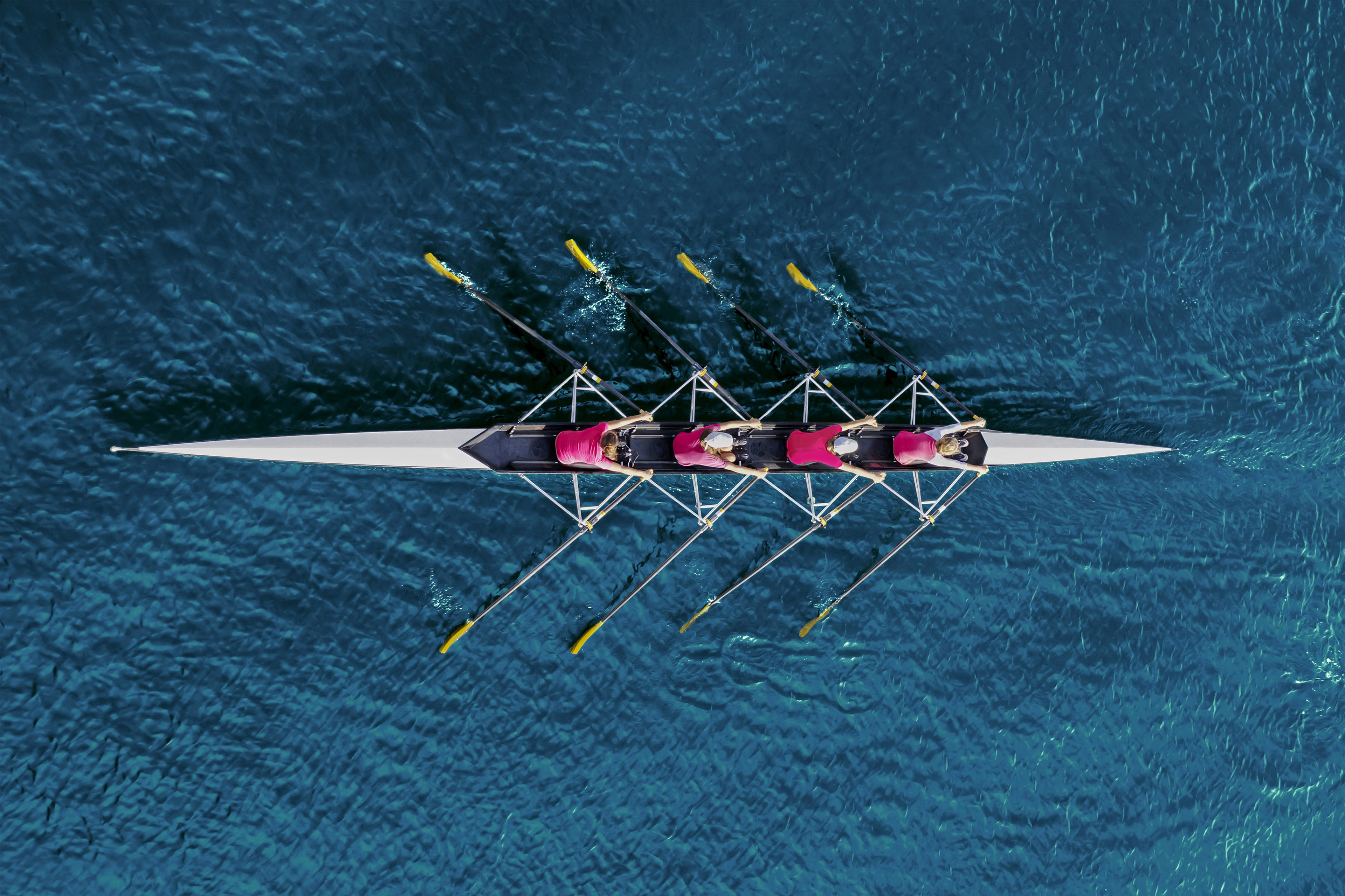 Team of women rowing boat