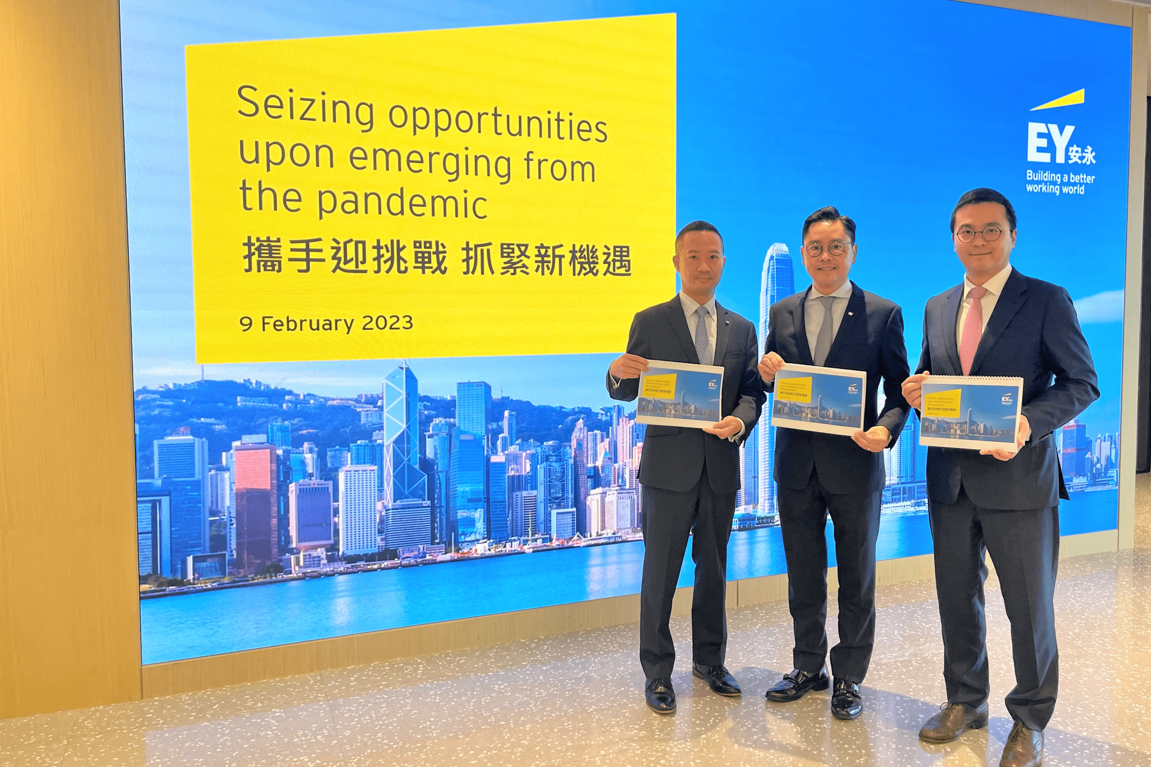 Three businessmen posed for a photograph by holding a magazine