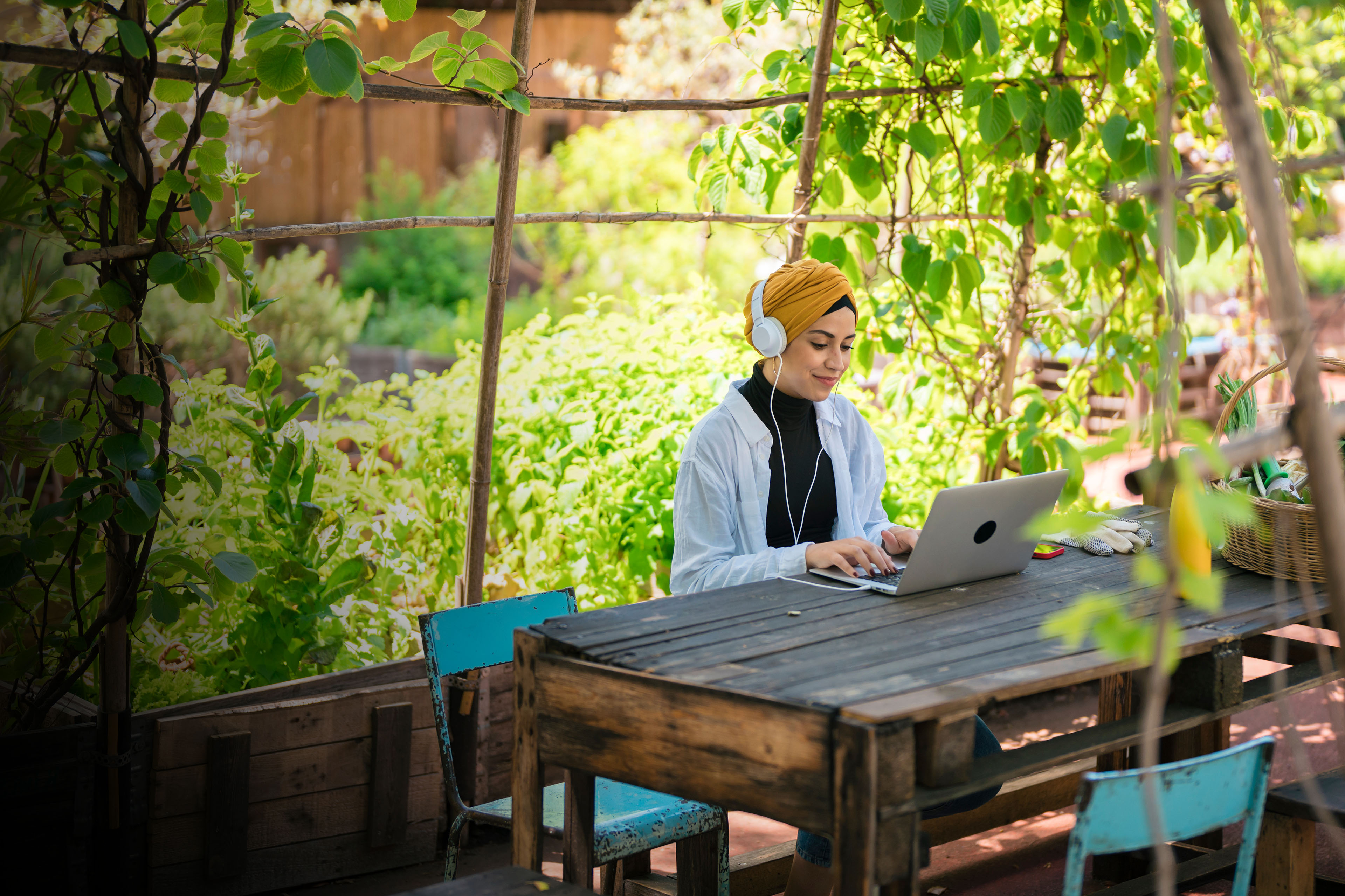 Smiling woman in headphones working on laptop