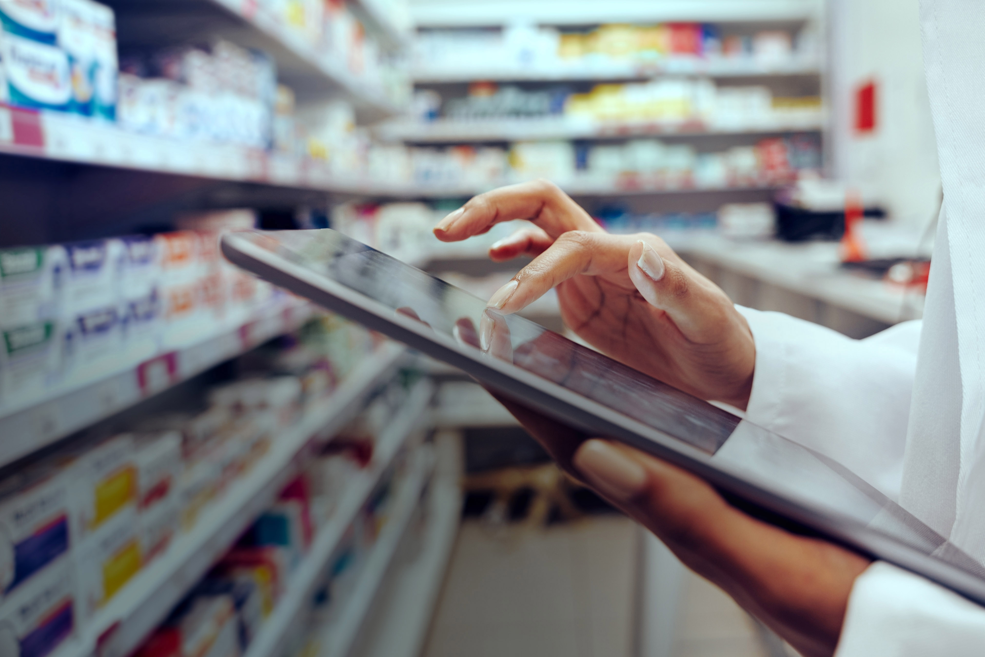 Hands of pharmacist checking inventory using digital tablet