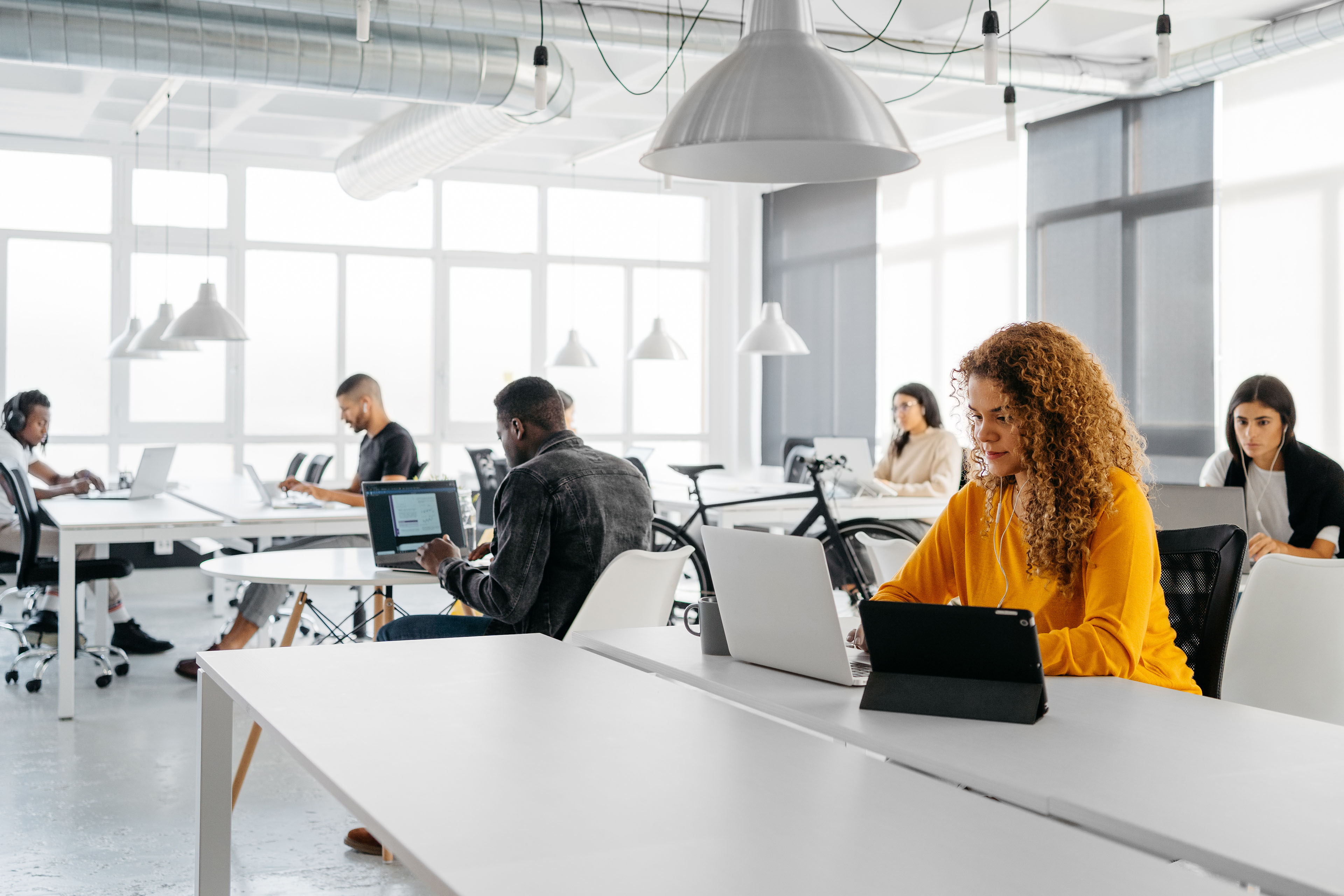 Multiethnic group of people focused on their laptops in a modern coworking space