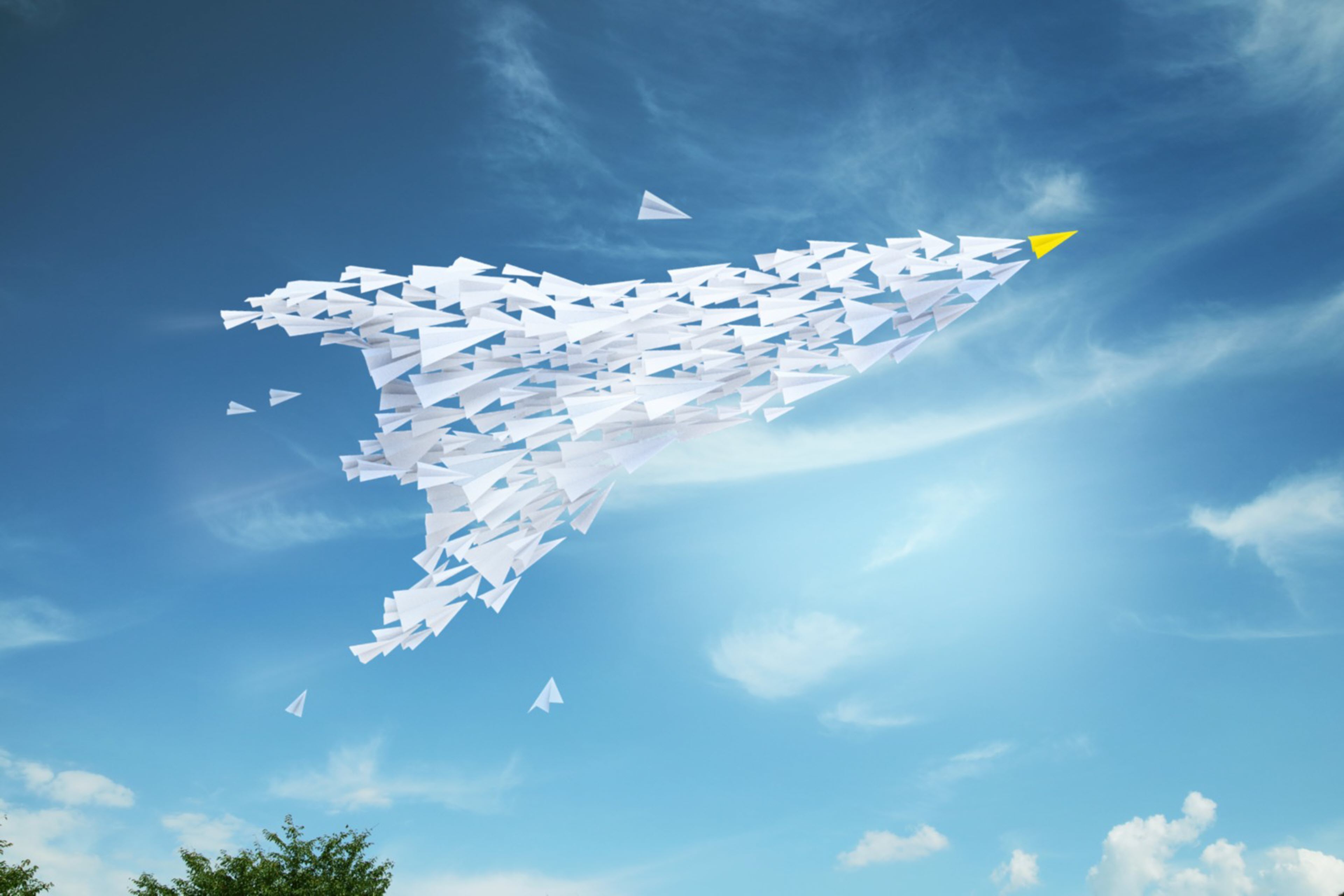 Paper planes in the shape of an airplane in the sky