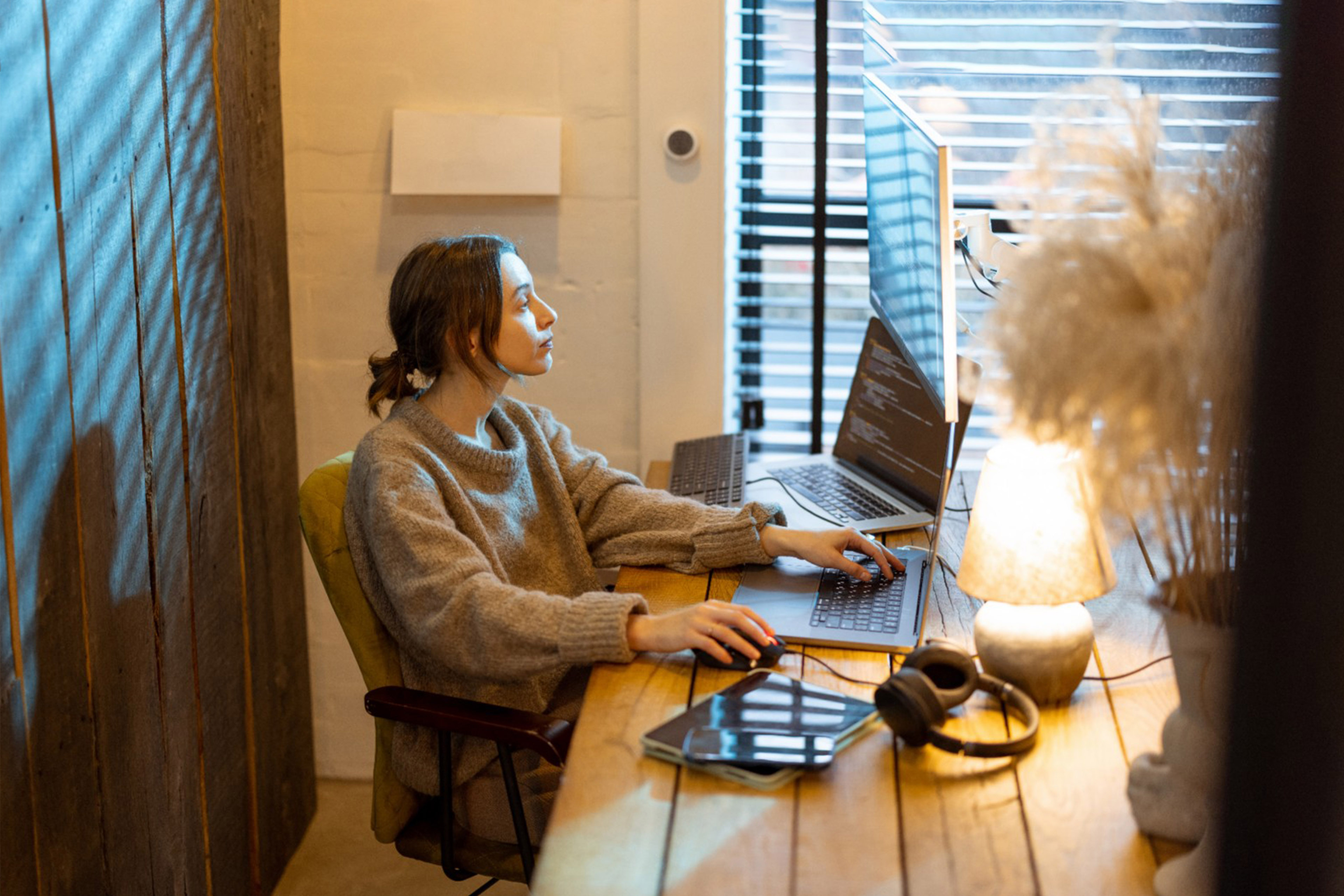 Woman sitting at workplace at cozy home office interior